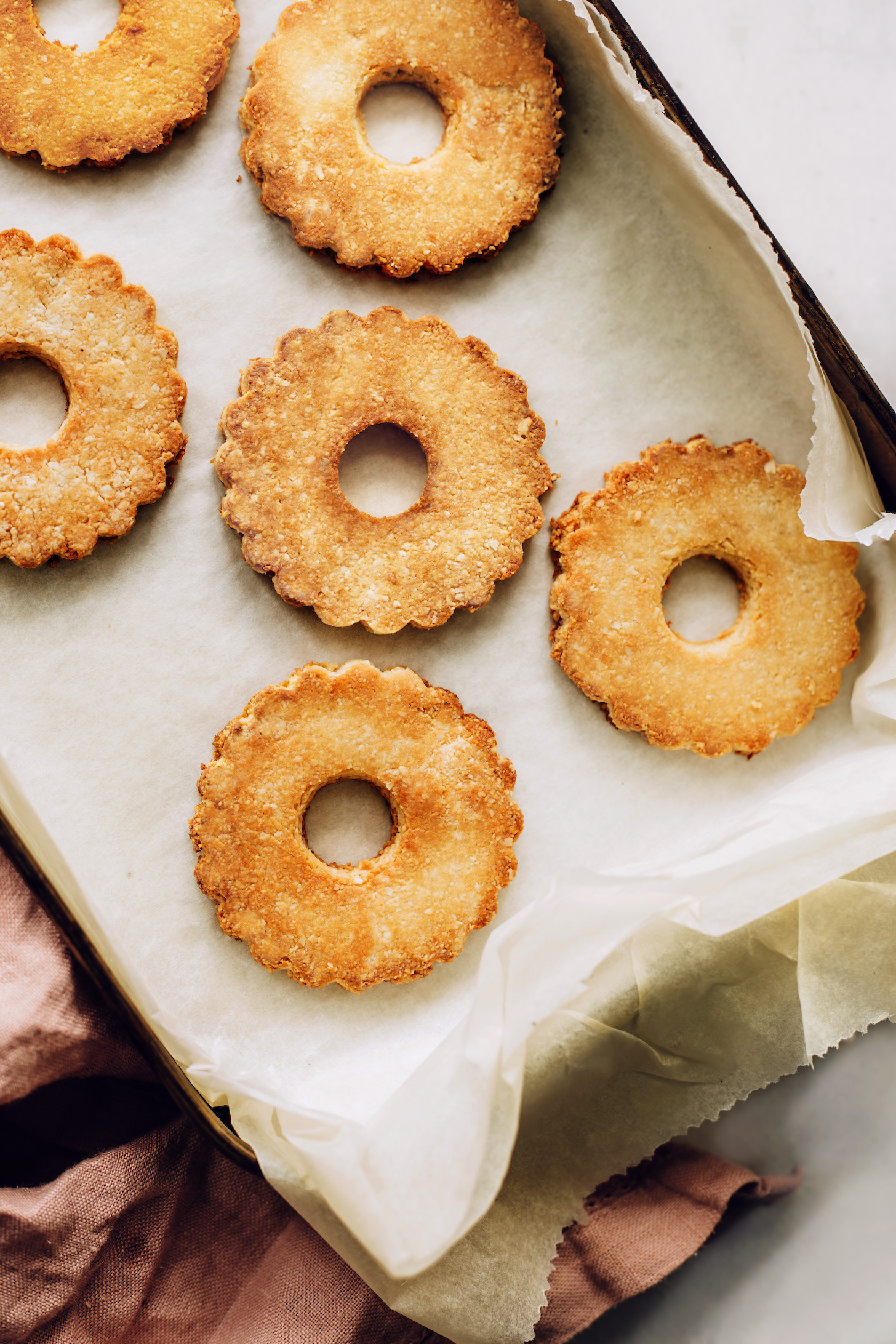 Parchment-lined baking sheet filled with the base for samoas