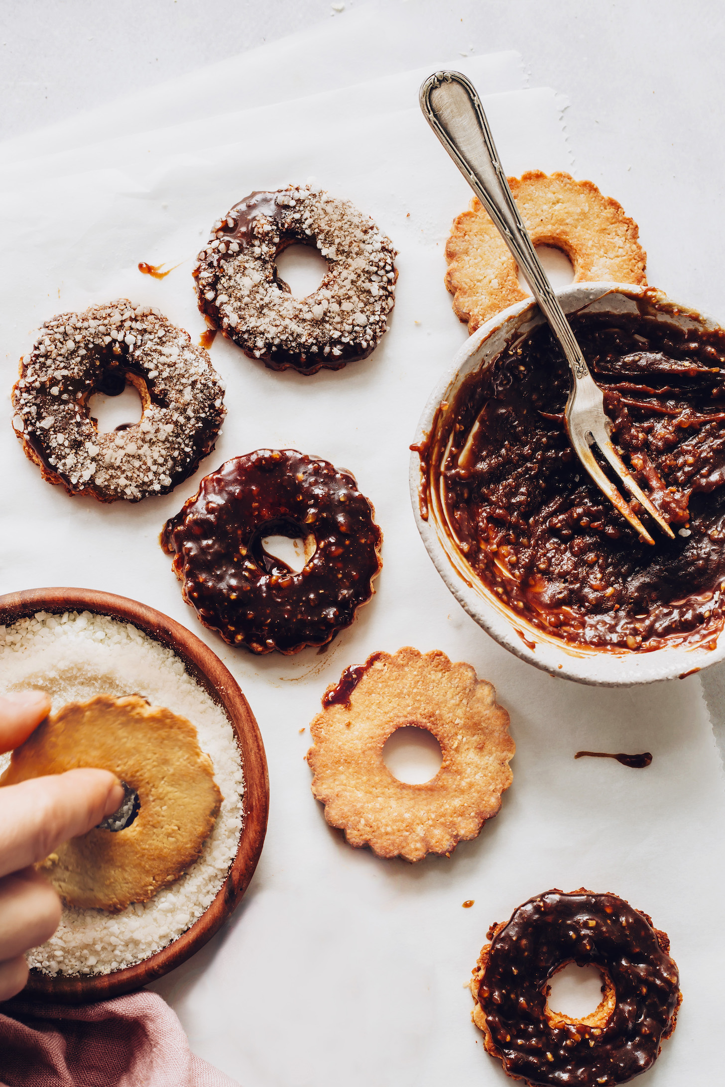 Dipping cookies into shredded coconut and melted chocolate