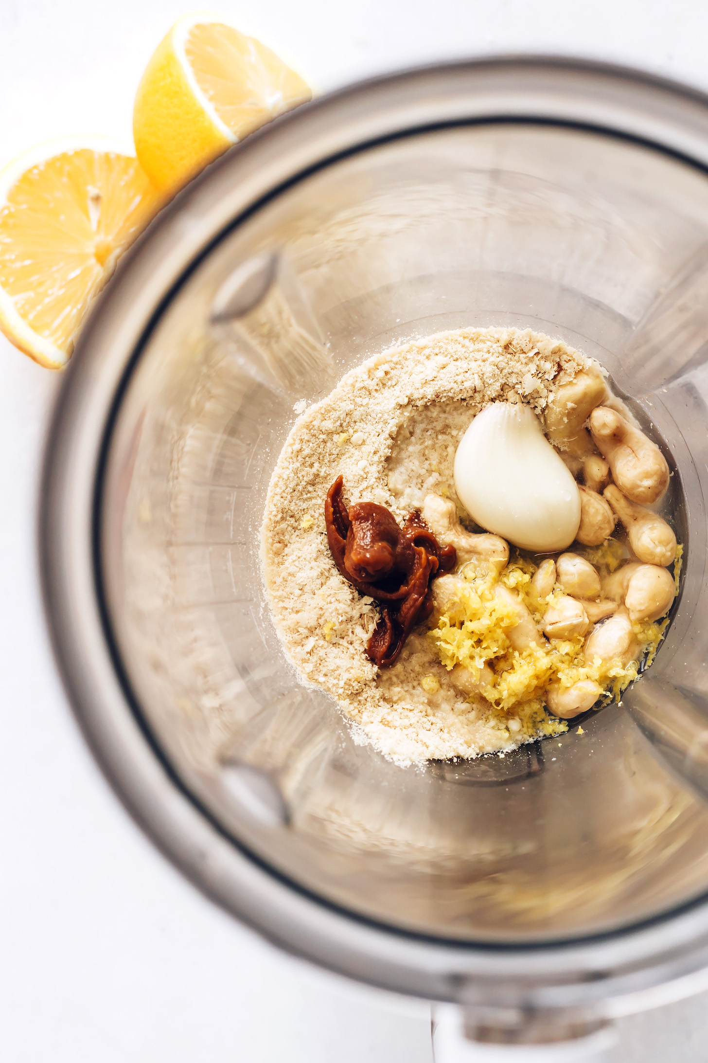 Blender with cashews, water, lemon, garlic, miso, nutritional yeast, sea salt, olive oil, and vegan parmesan cheese