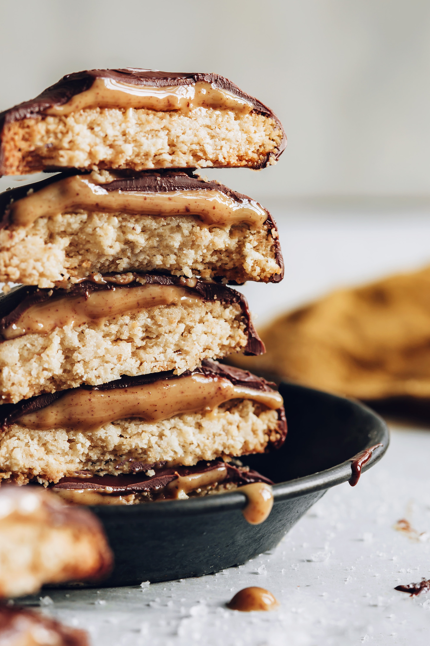 Stack of homemade tagalongs with layers of shortbread cookies, peanut butter, and chocolate