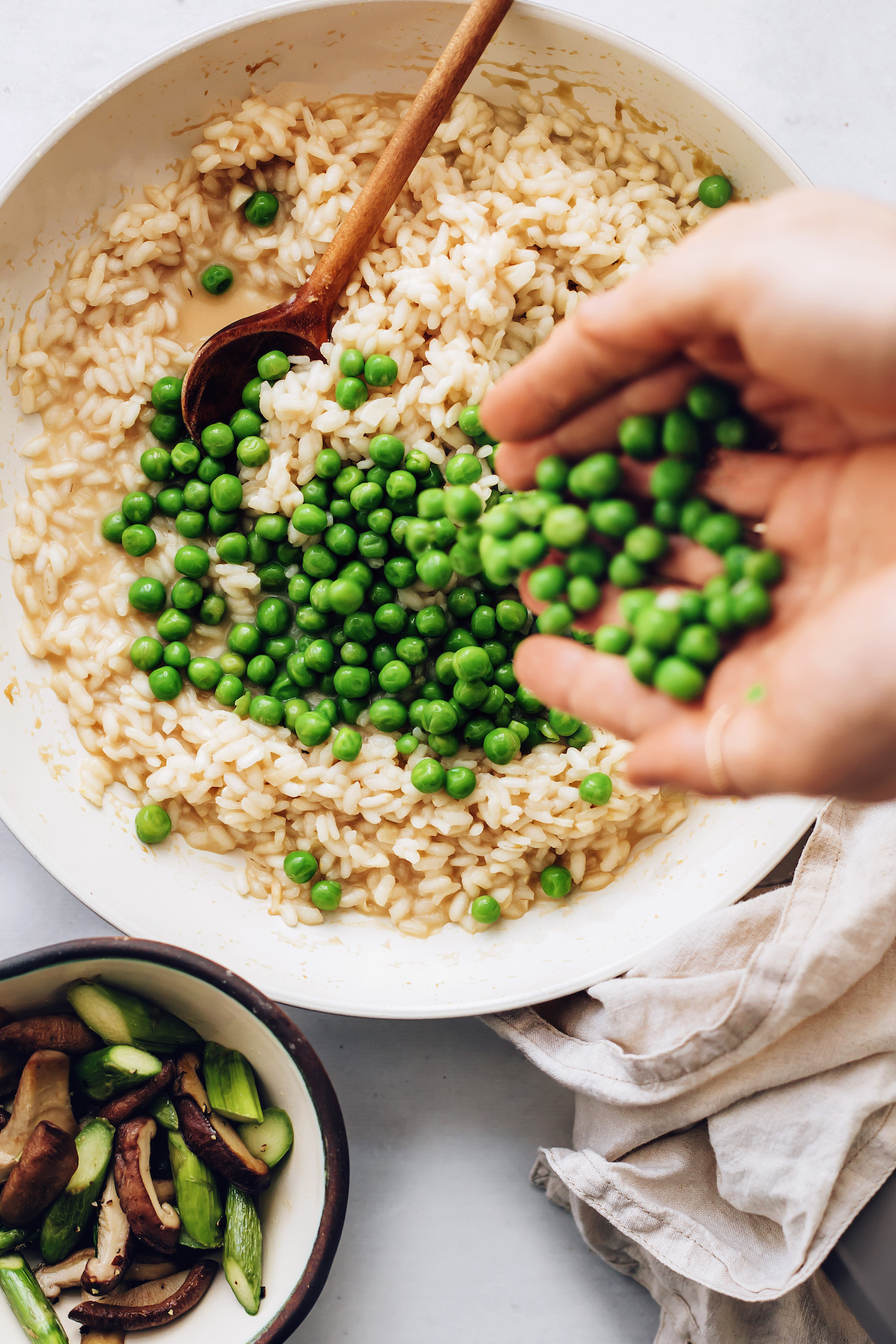 Adding green peas to arborio rice and miso broth