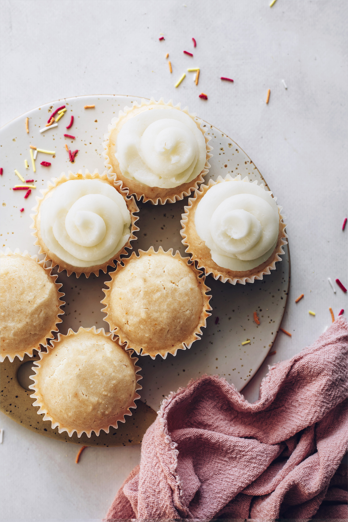 Tray of vanilla cupcakes with half of them frosted