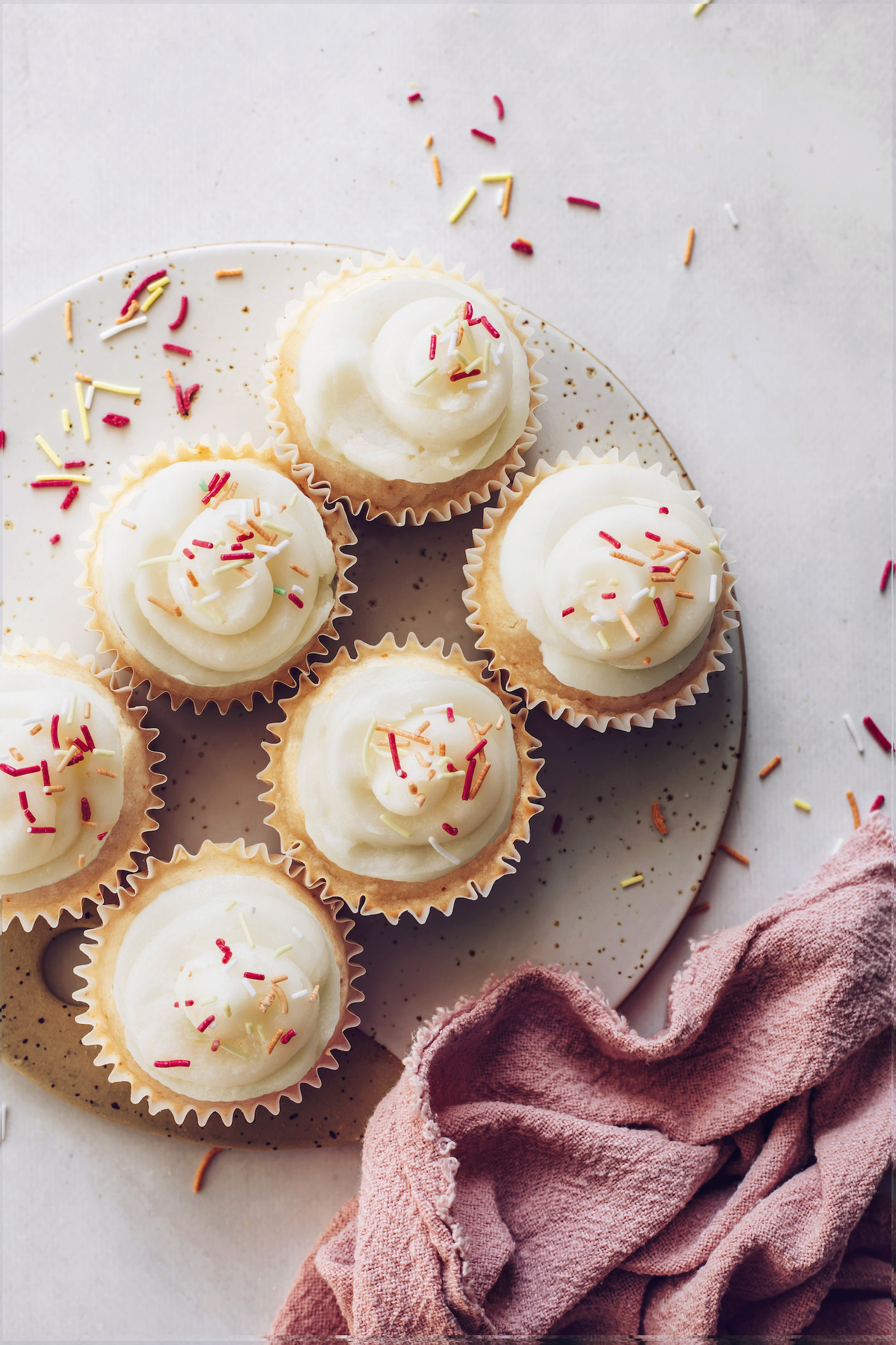 Vanilla cupcakes topped with frosting and sprinkles