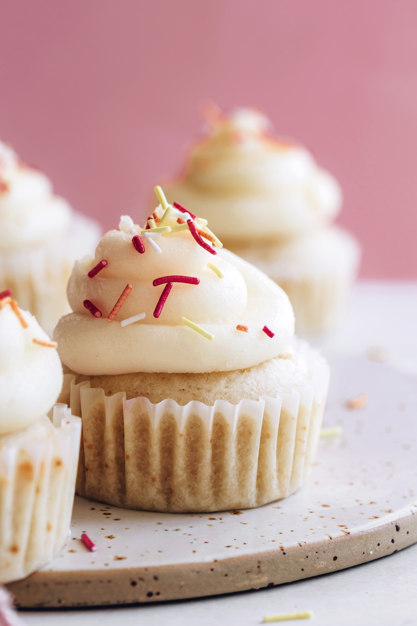 Side view of a vegan vanilla cupcake with buttercream frosting and sprinkles