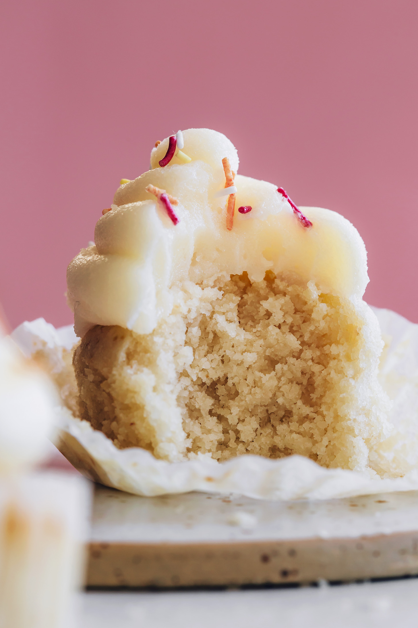 Partially eaten fluffy vegan vanilla cupcake