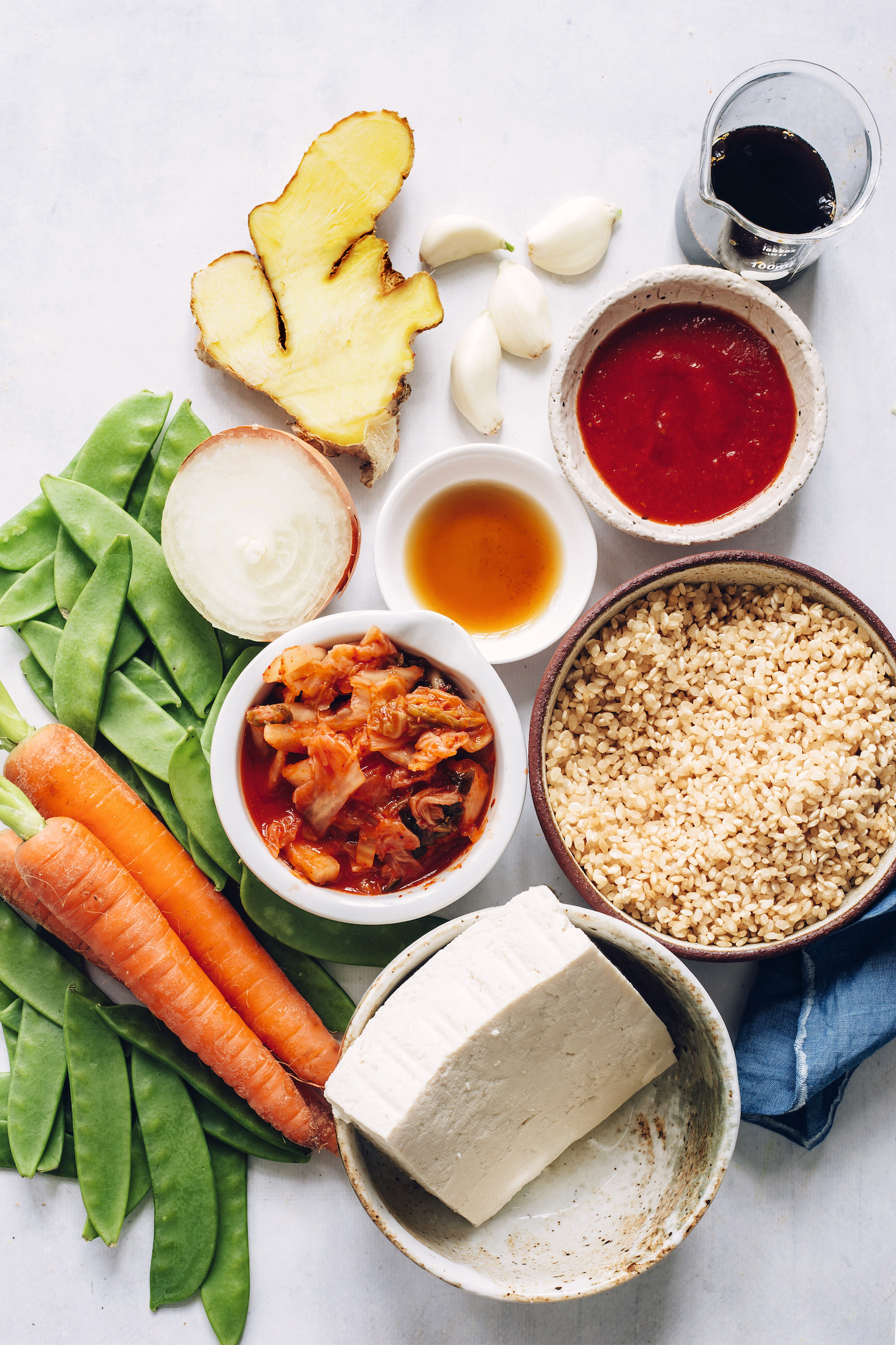 Carrots, peas, tofu, kimchi, rice, onion, garlic, ginger, toasted sesame oil, gochujang, and tamari