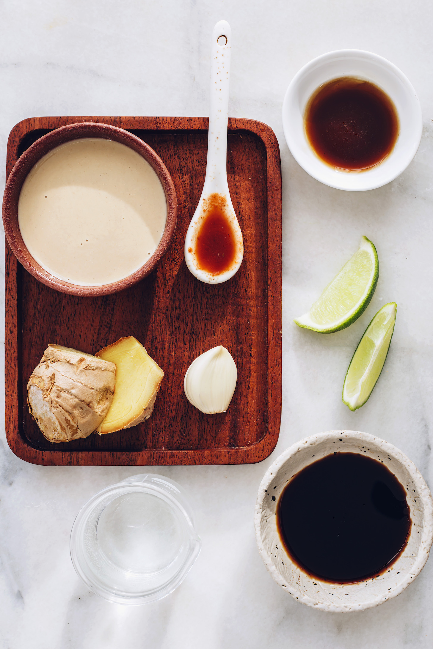 Tahini, ginger, garlic, chili garlic sauce, lime, maple syrup, tamari, and water
