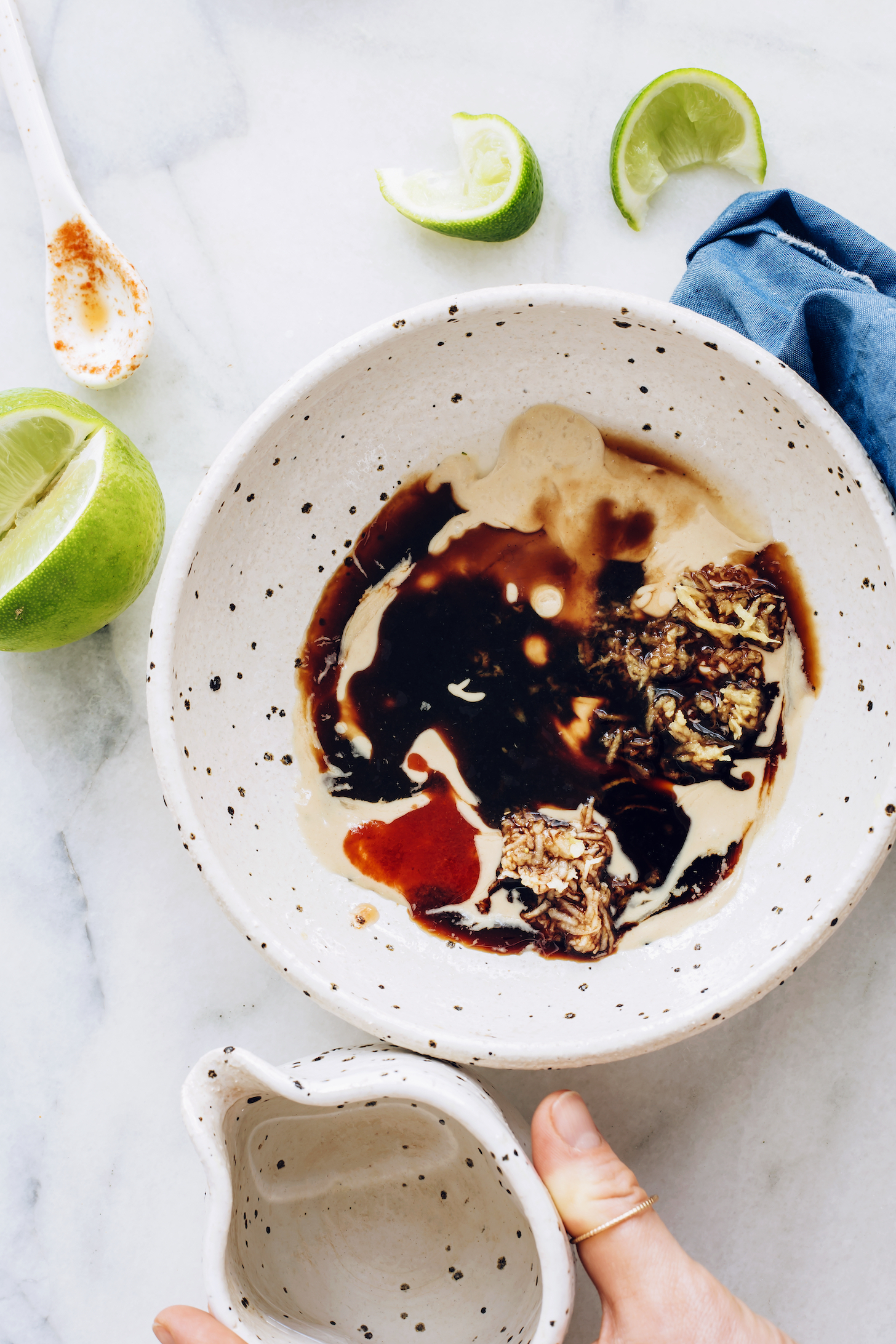 Bowl of tamari, tahini, lime juice, ginger, garlic, maple syrup, and chili garlic sauce