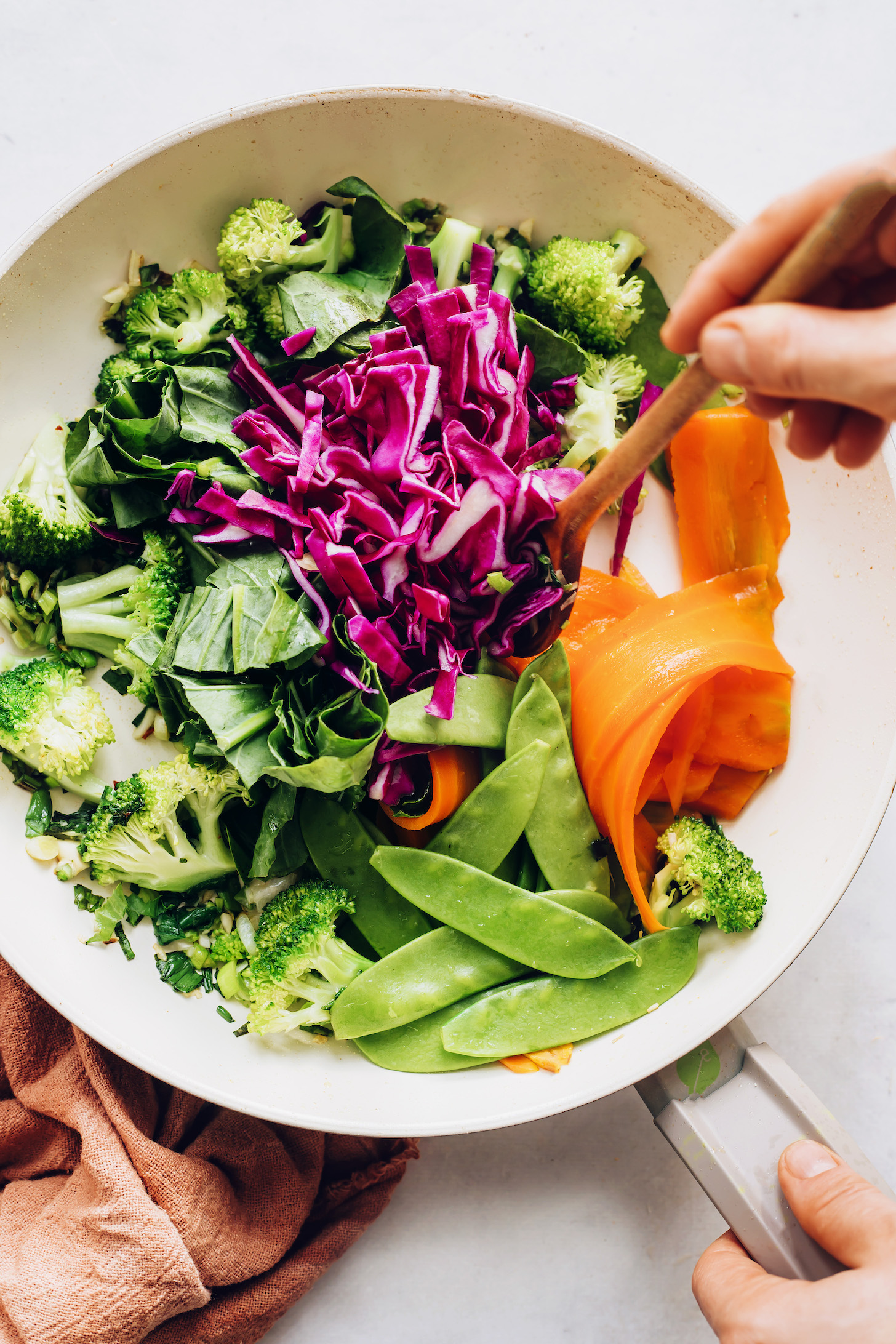 Sautéing fresh broccoli, cabbage, carrots, peas, and greens