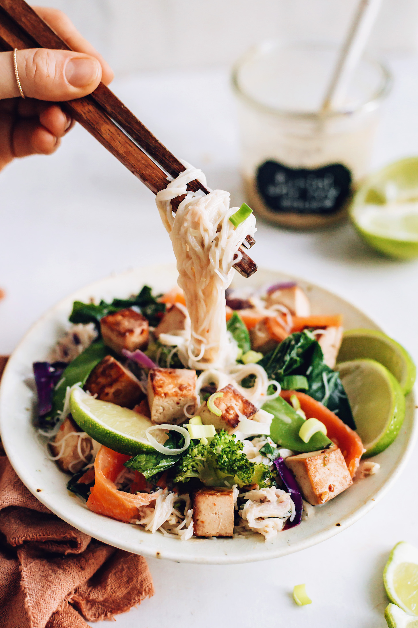 Chopsticks holding a bite of vegan noodle stir fry