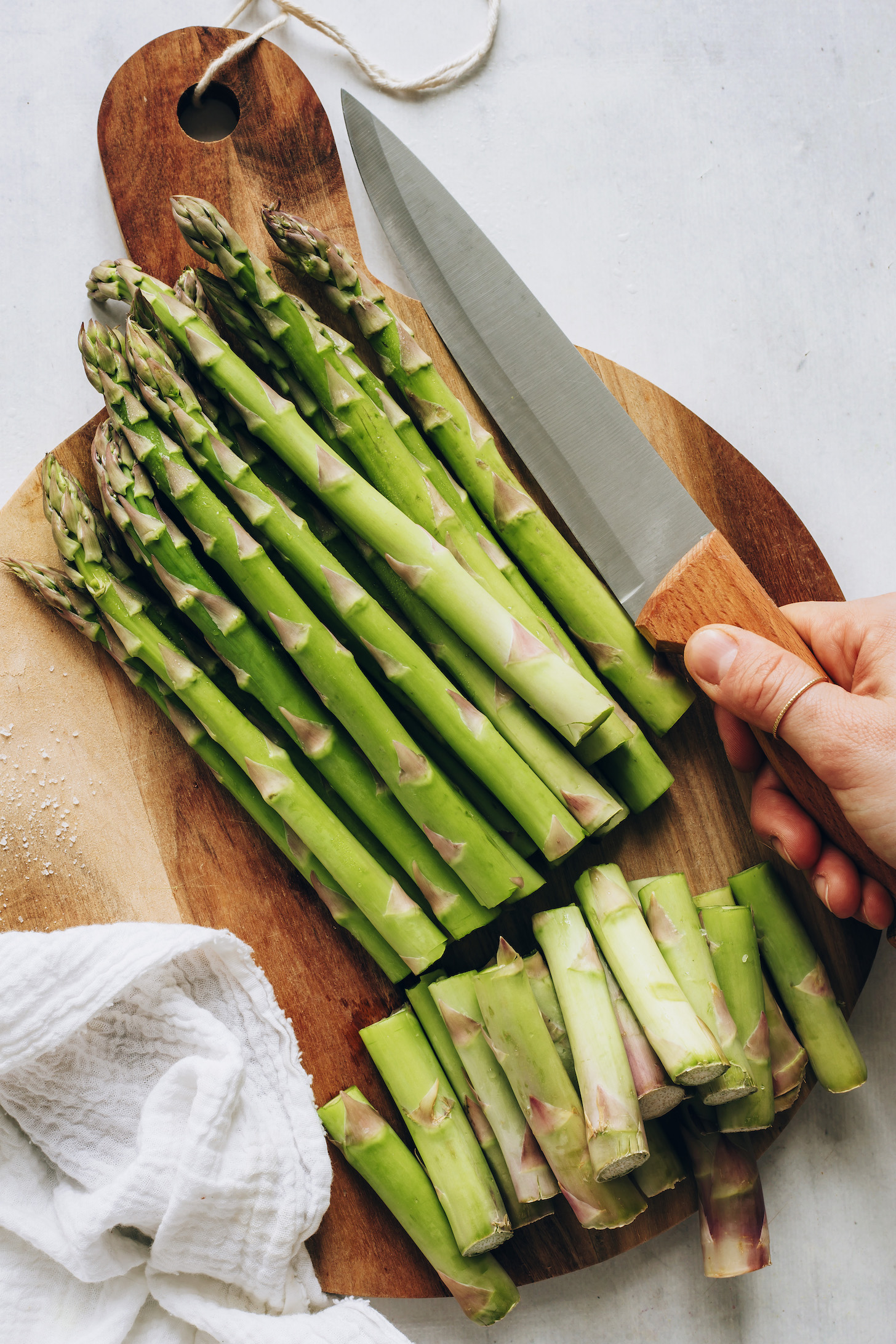Cutting board with woody ends trimmed off the asparagus
