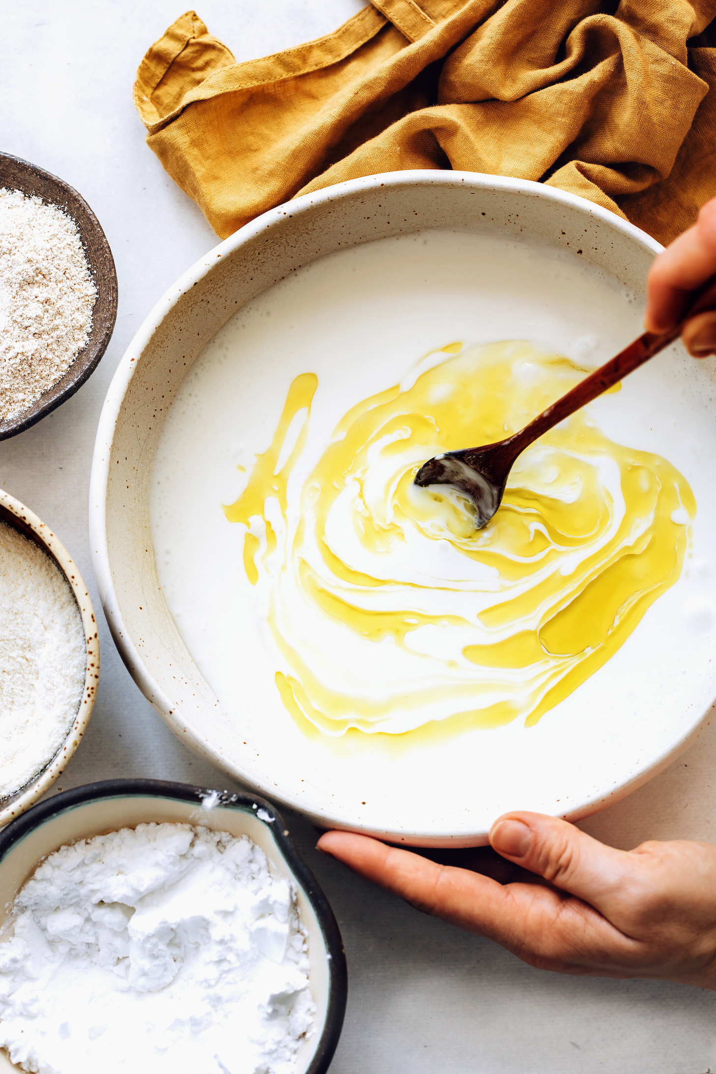 Stirring coconut milk and olive oil in a mixing bowl