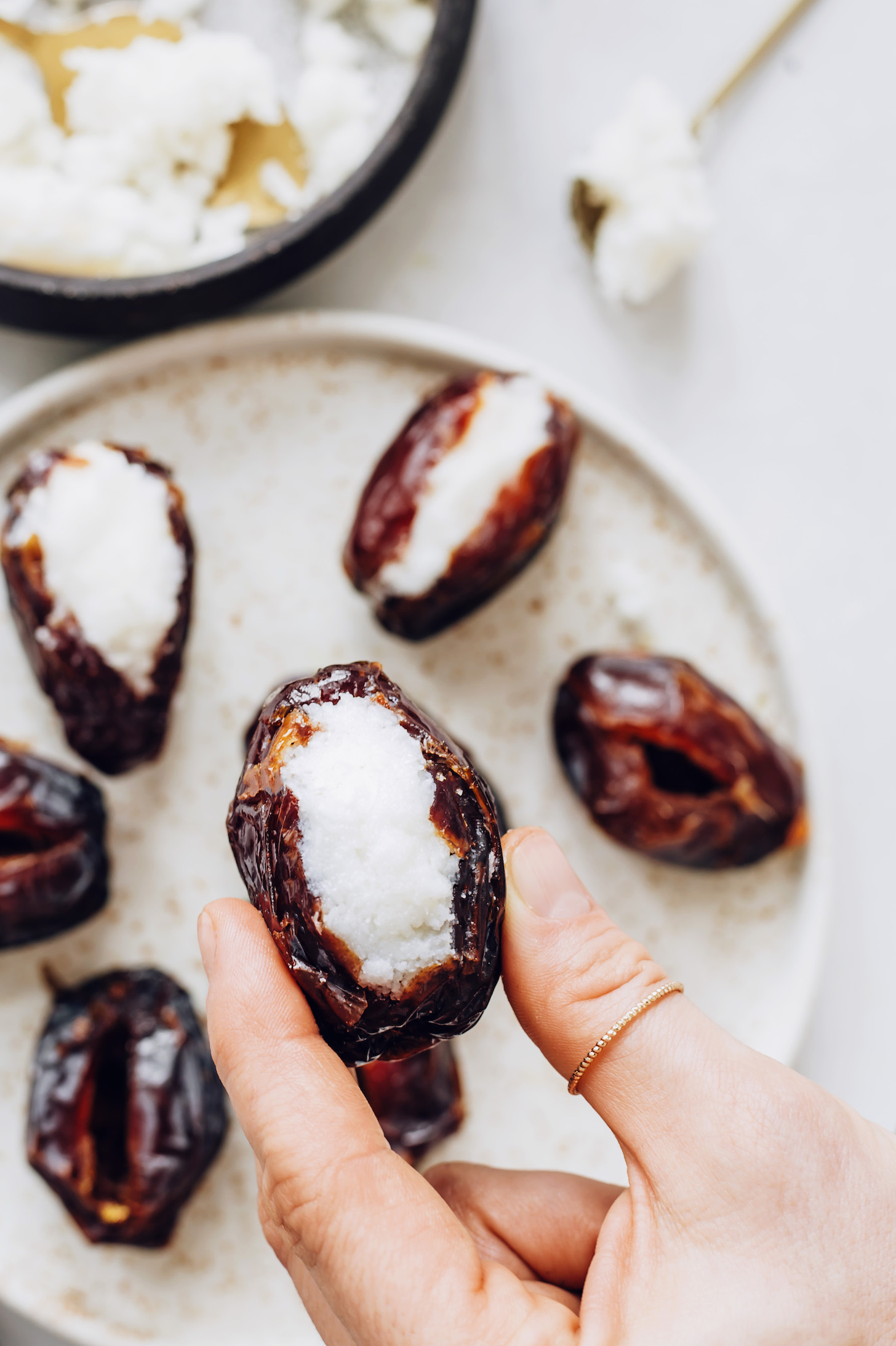 Holding a medjool date stuffed with coconut butter