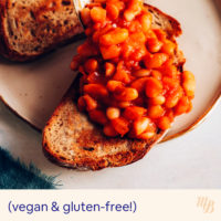 Scooping British-inspired baked beans onto slices of toast