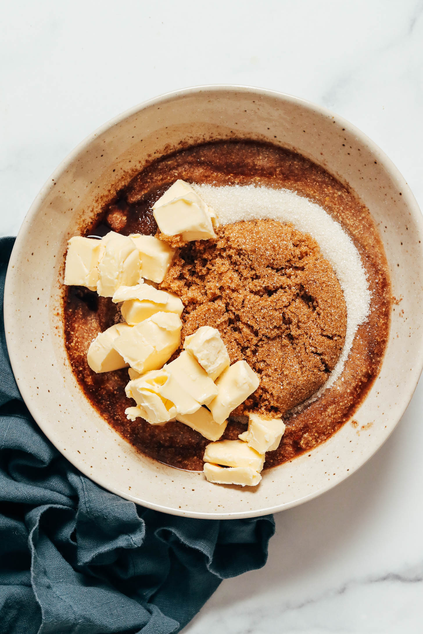 Bowl of brown sugar, cane sugar, vanilla, flax eggs, and cubed vegan butter