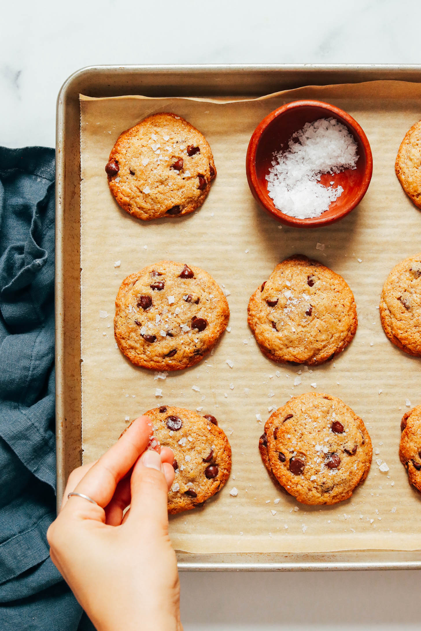 Sprinkling sea salt over warm chocolate chip cookies