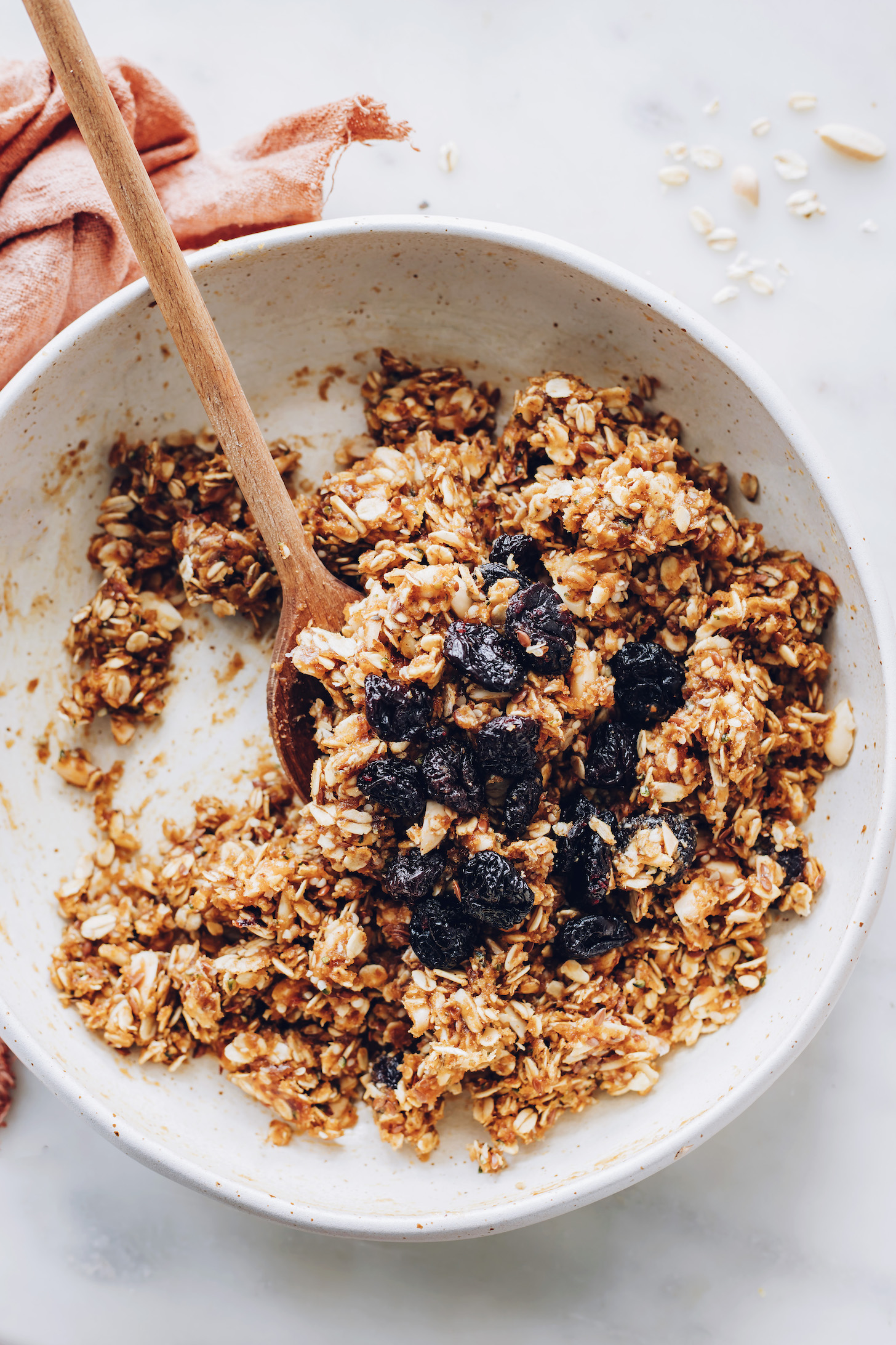 Bowl of granola bar batter topped with extra dried cherries