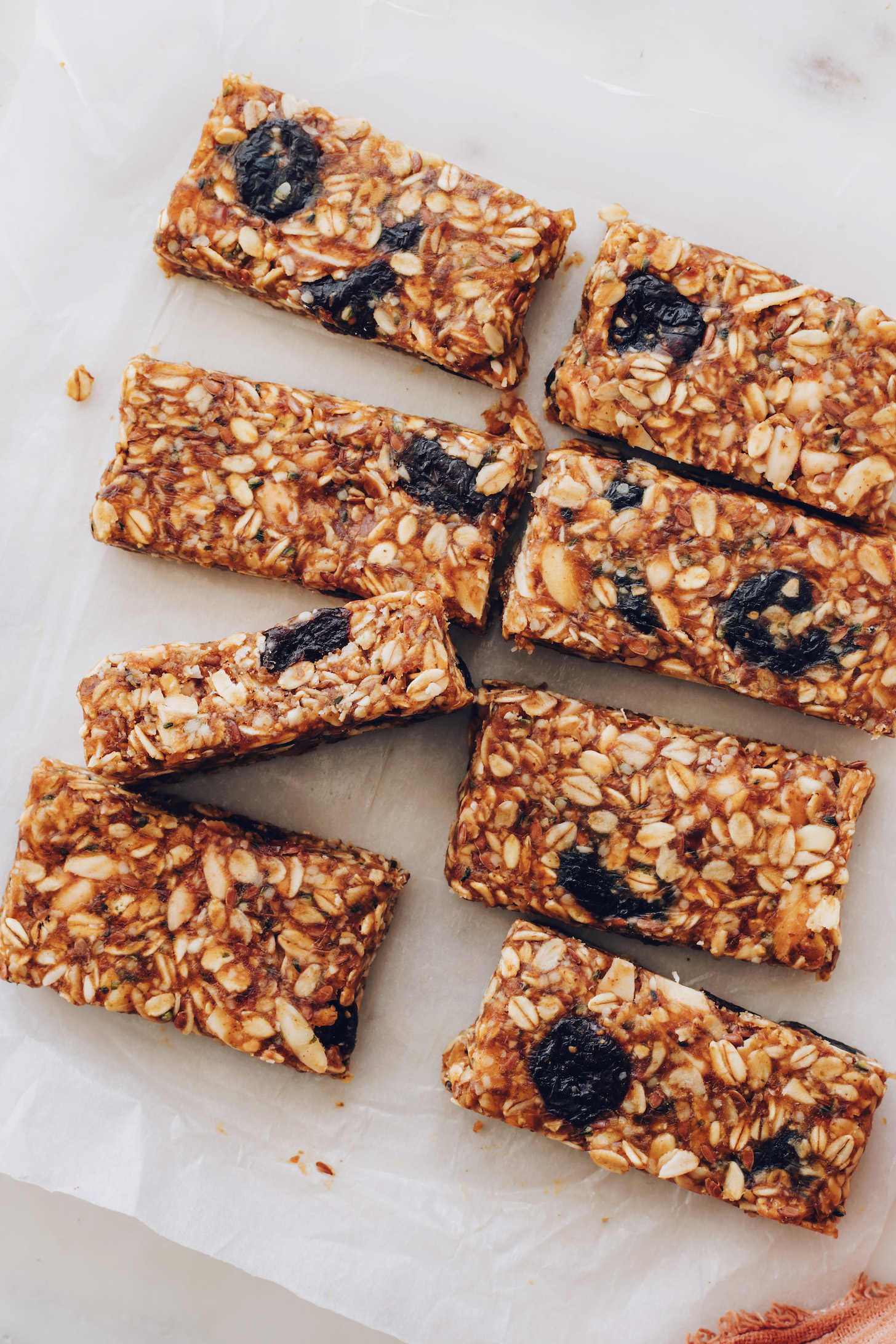 Sliced cherry almond granola bars on a piece of parchment paper