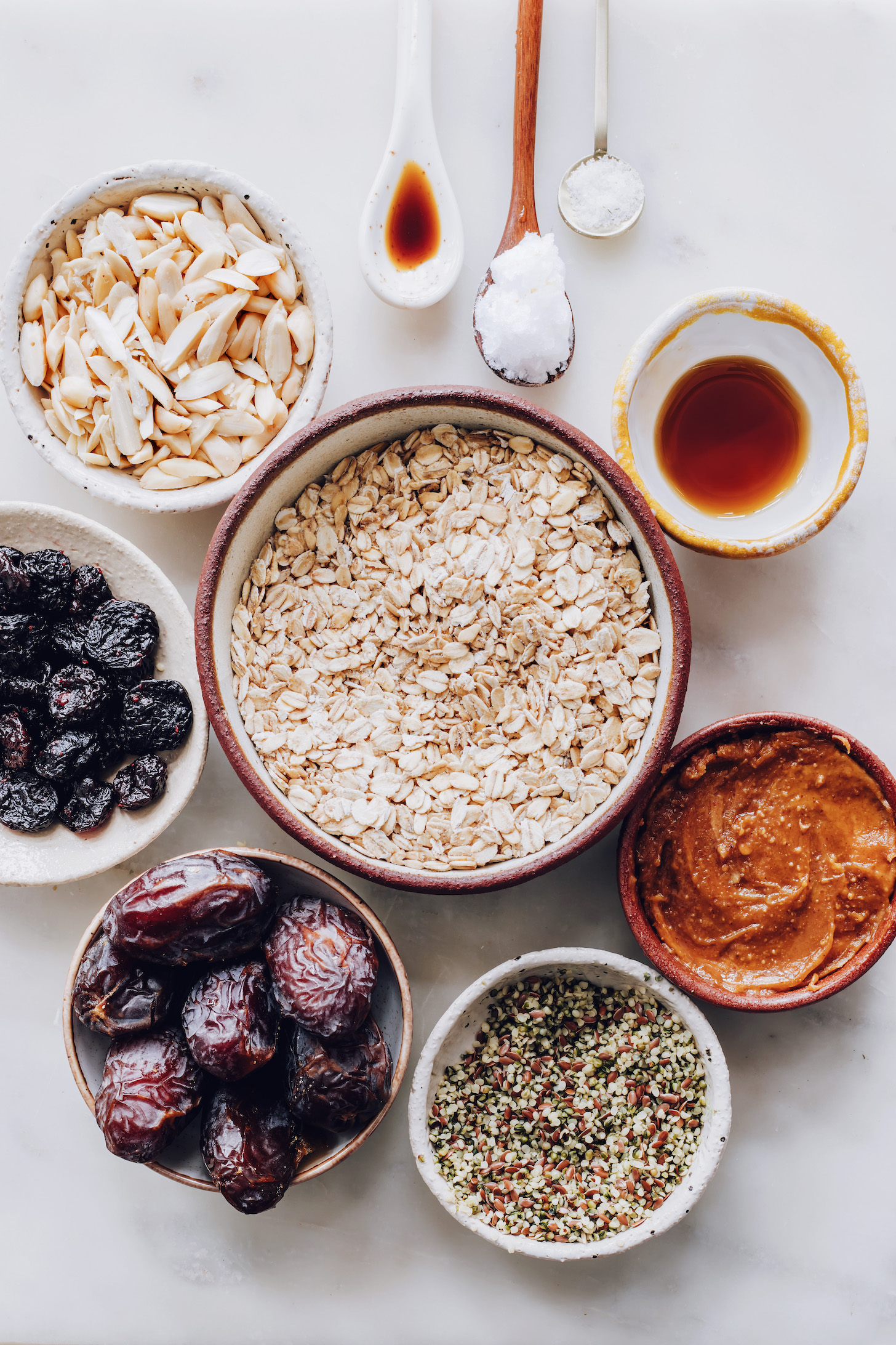 Almond, dried cherries, oats, vanilla, coconut oil, salt, maple syrup, nut butter, seeds, and dates