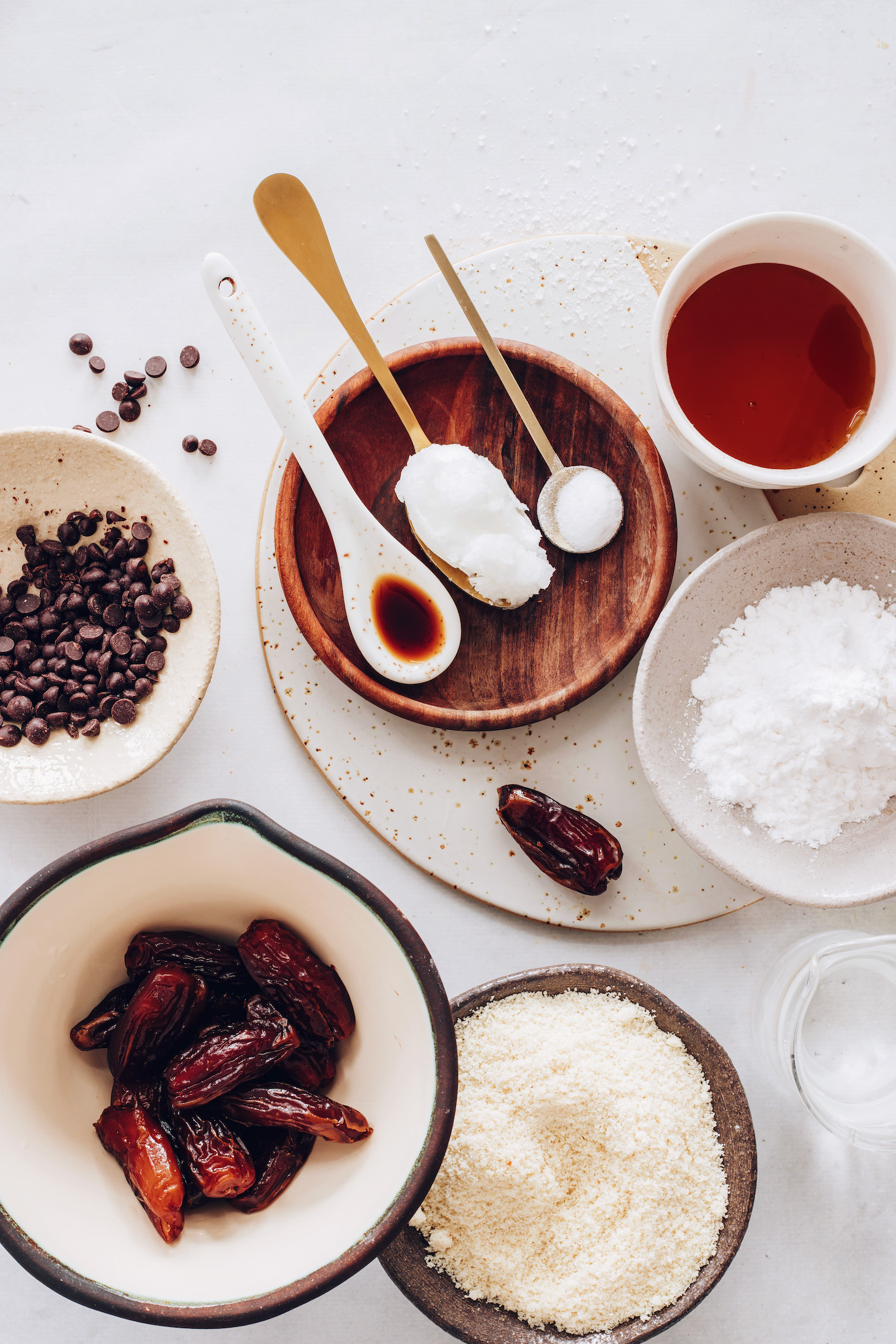 Dates, almond flour, arrowroot starch, water, maple syrup, salt, baking soda, coconut oil, vanilla, and chocolate chips for making homemade Twix bars