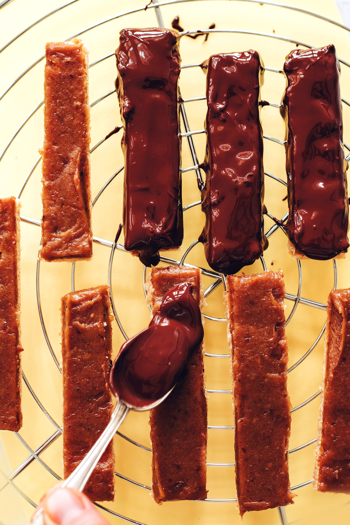 Pouring melted chocolate to make homemade Twix bars