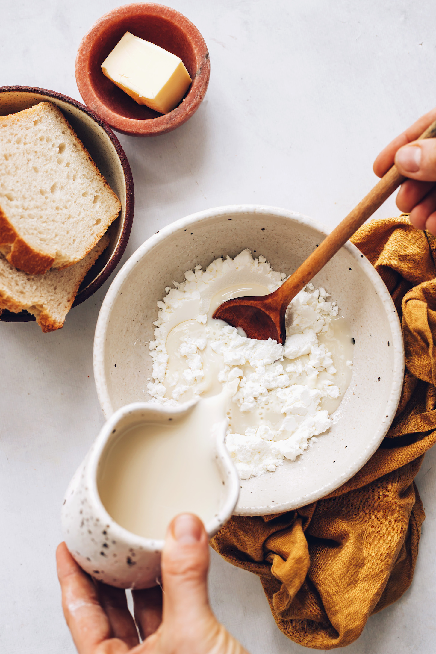 Pouring almond milk over a bowl of cornstarch