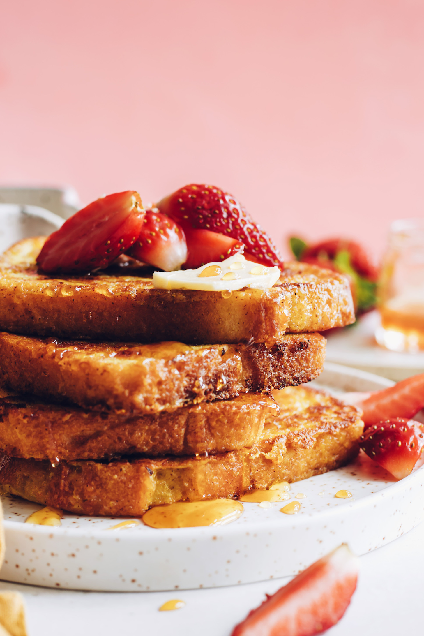 Stack of slices of vegan French toast with vegan butter and strawberries
