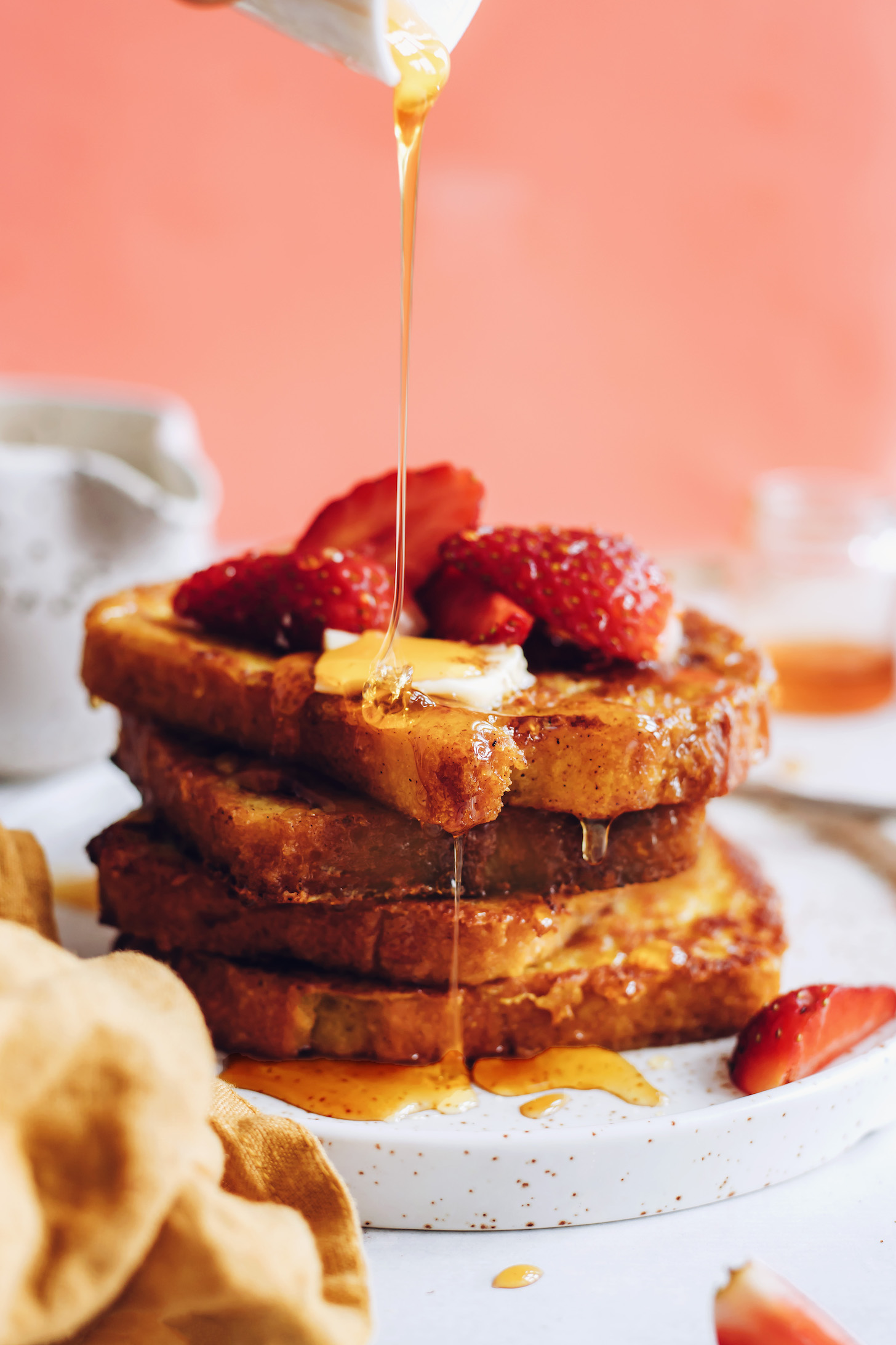 Drizzling slices of vegan French toast with maple syrup