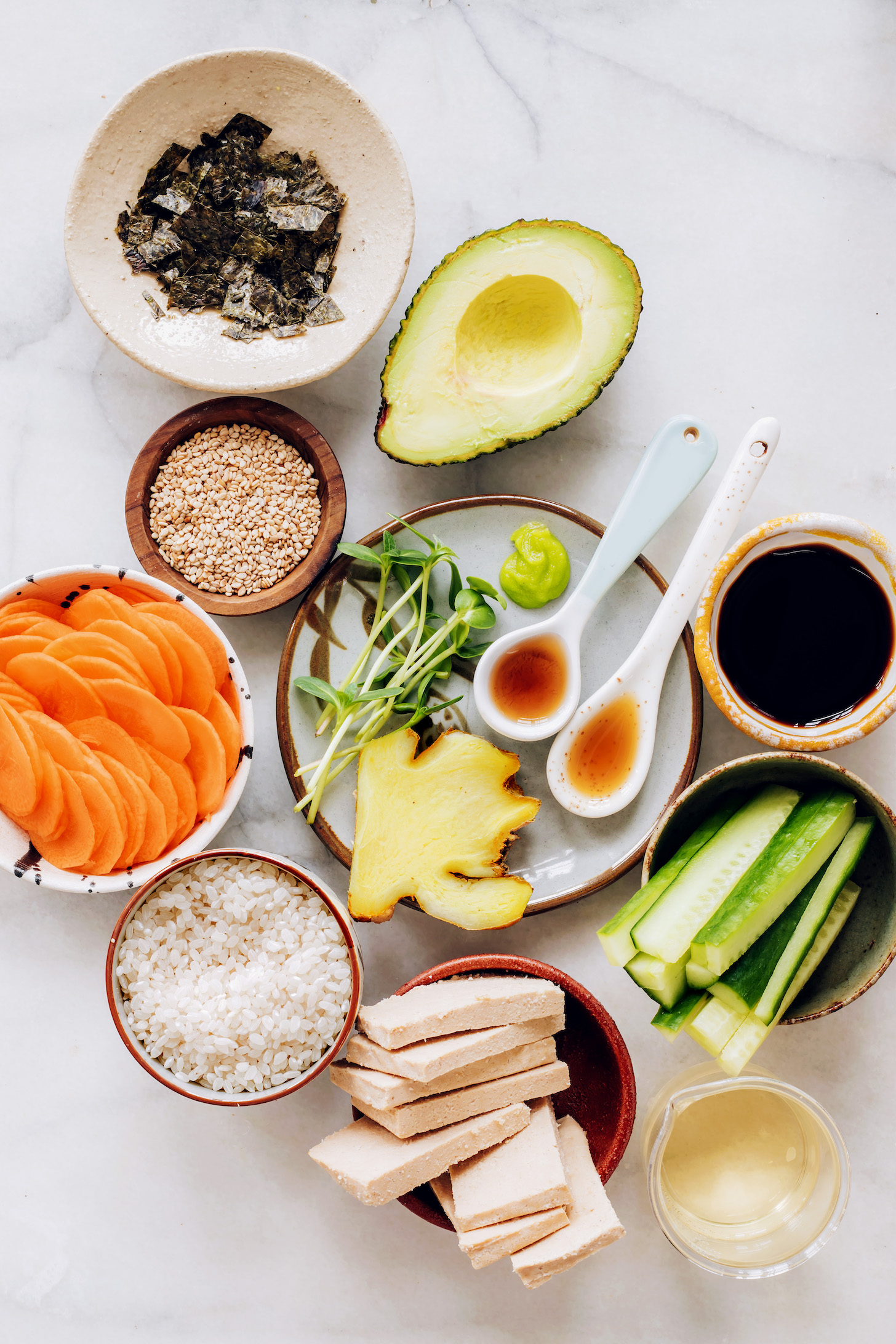 Rice, tofu, cucumber, tamari, maple syrup, sesame oil, ginger, wasabi, sprouts, avocado, sesame seeds, nori, and carrots