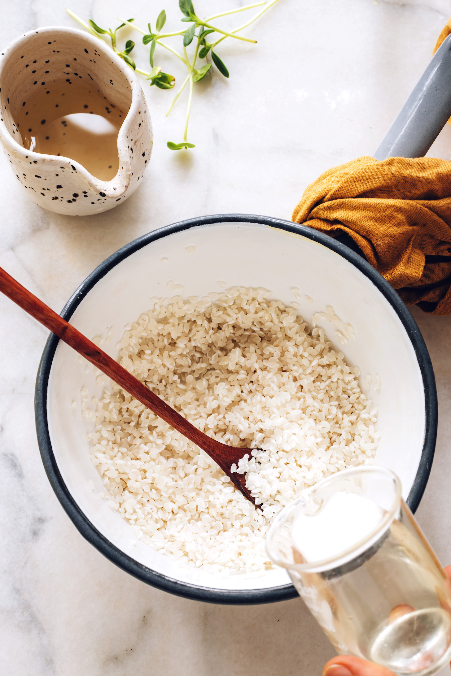Pouring water into a saucepan of sushi rice