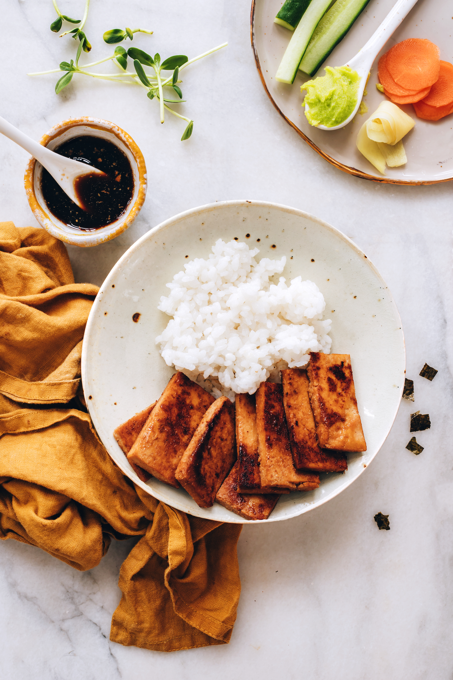 Vegan sushi bowl next to a bowl of tamari