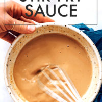 Whisking tahini stir fry sauce in a bowl