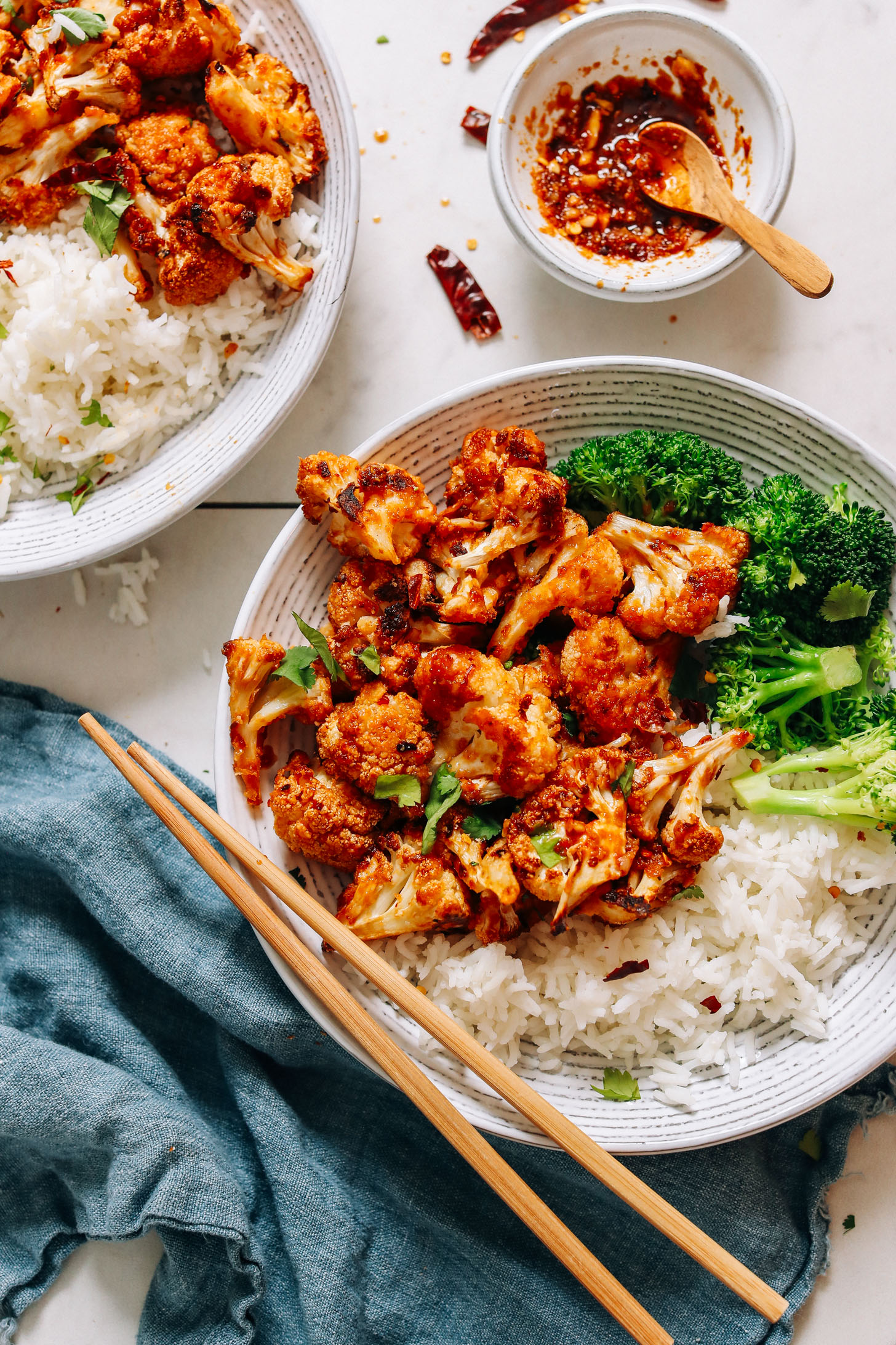Bowls of General Tso's Cauliflower and chili garlic sauce