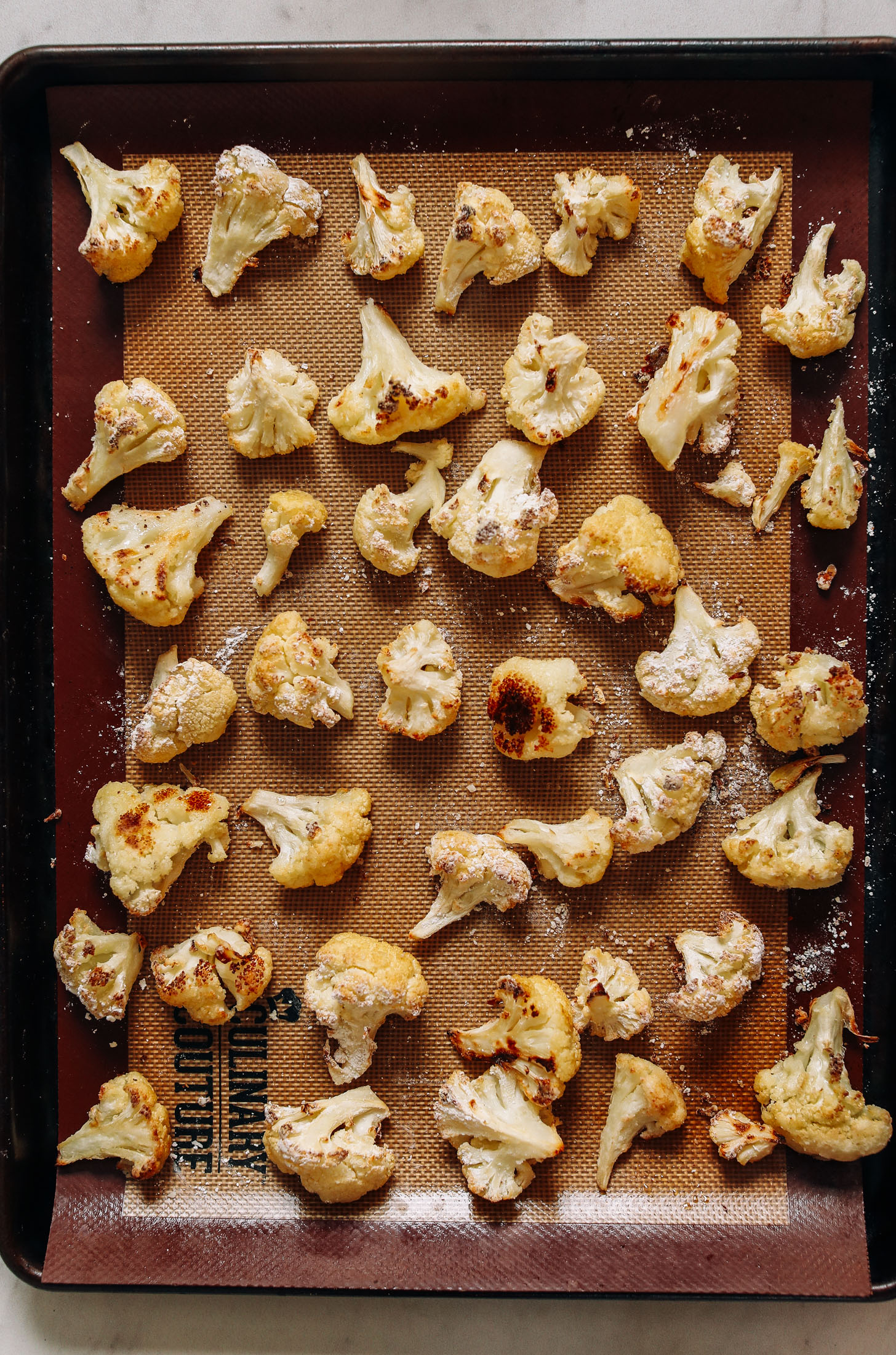 Baking sheet of roasted cauliflower with a crispy coating