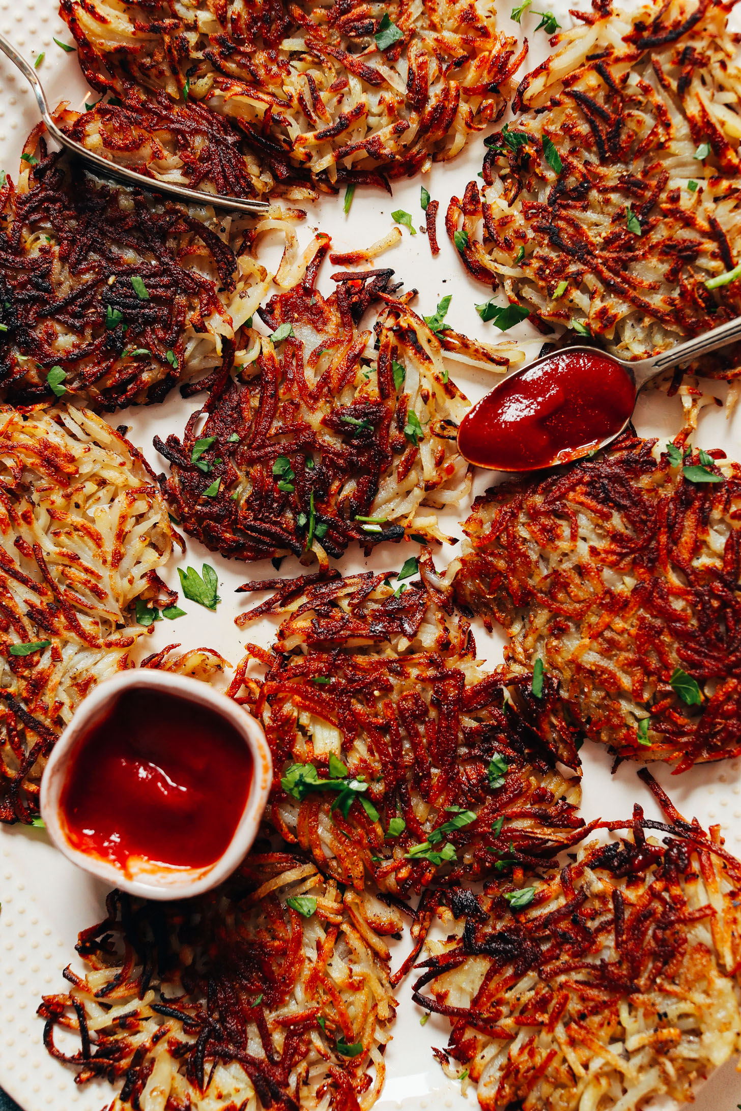 Crispy hash brown patties with a small bowl and spoonful of ketchup
