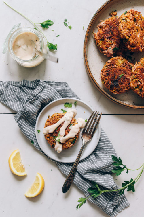 Plate of vegan crab cakes and one on a separate plate with vegan tartar sauce