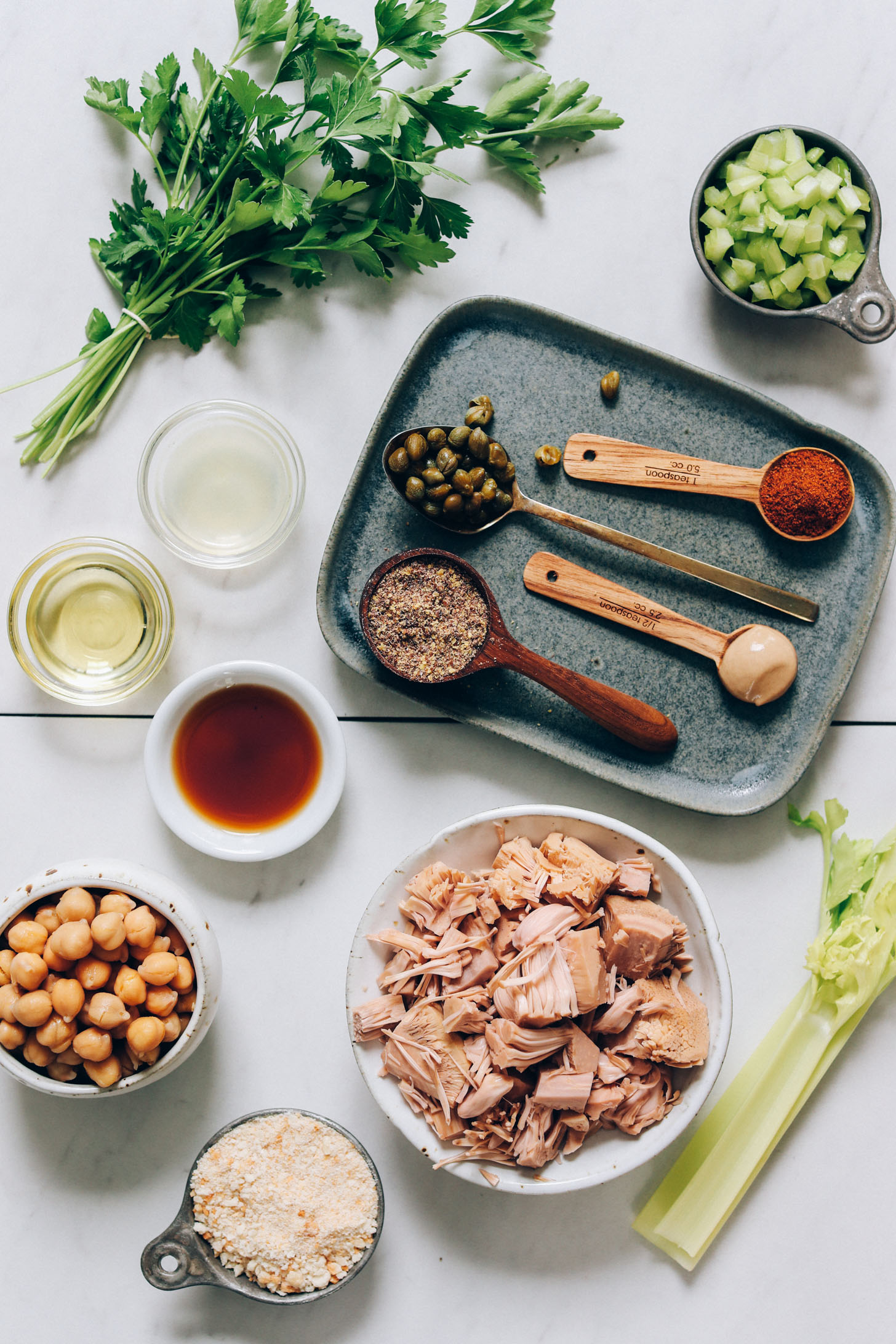 Parsley, celery, Old Bay seasoning, capers, mustard, flaxseed meal, avocado oil, worcestershire, chickpeas, breadcrumbs, jackfruit, and celery