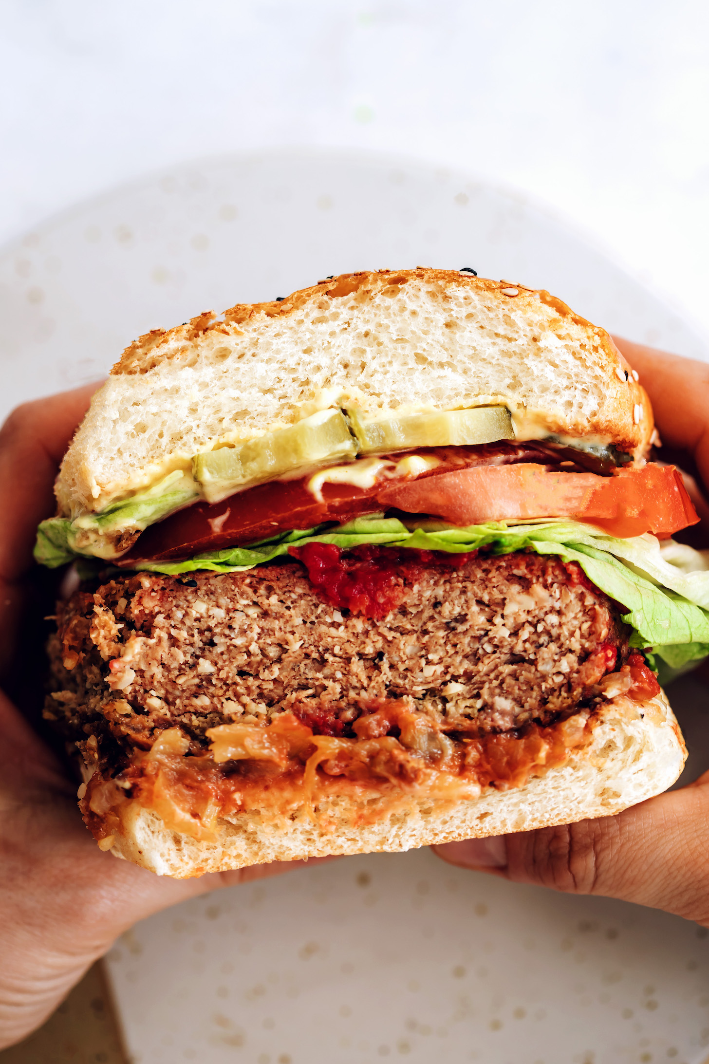 Holding a vegan burger patty in a bun with other toppings