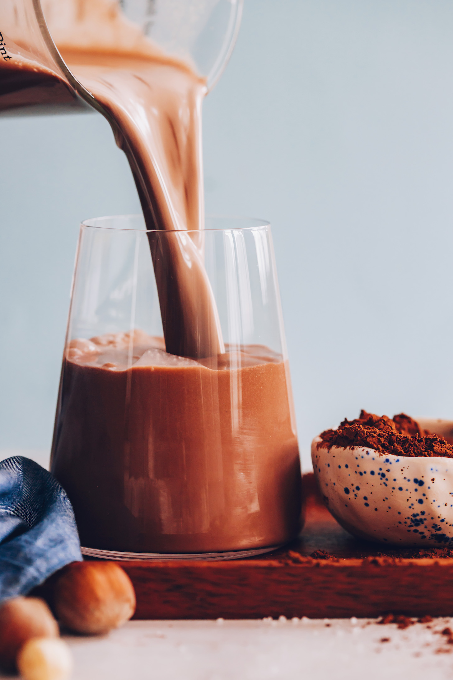 Pouring a glass of creamy chocolate hazelnut milk