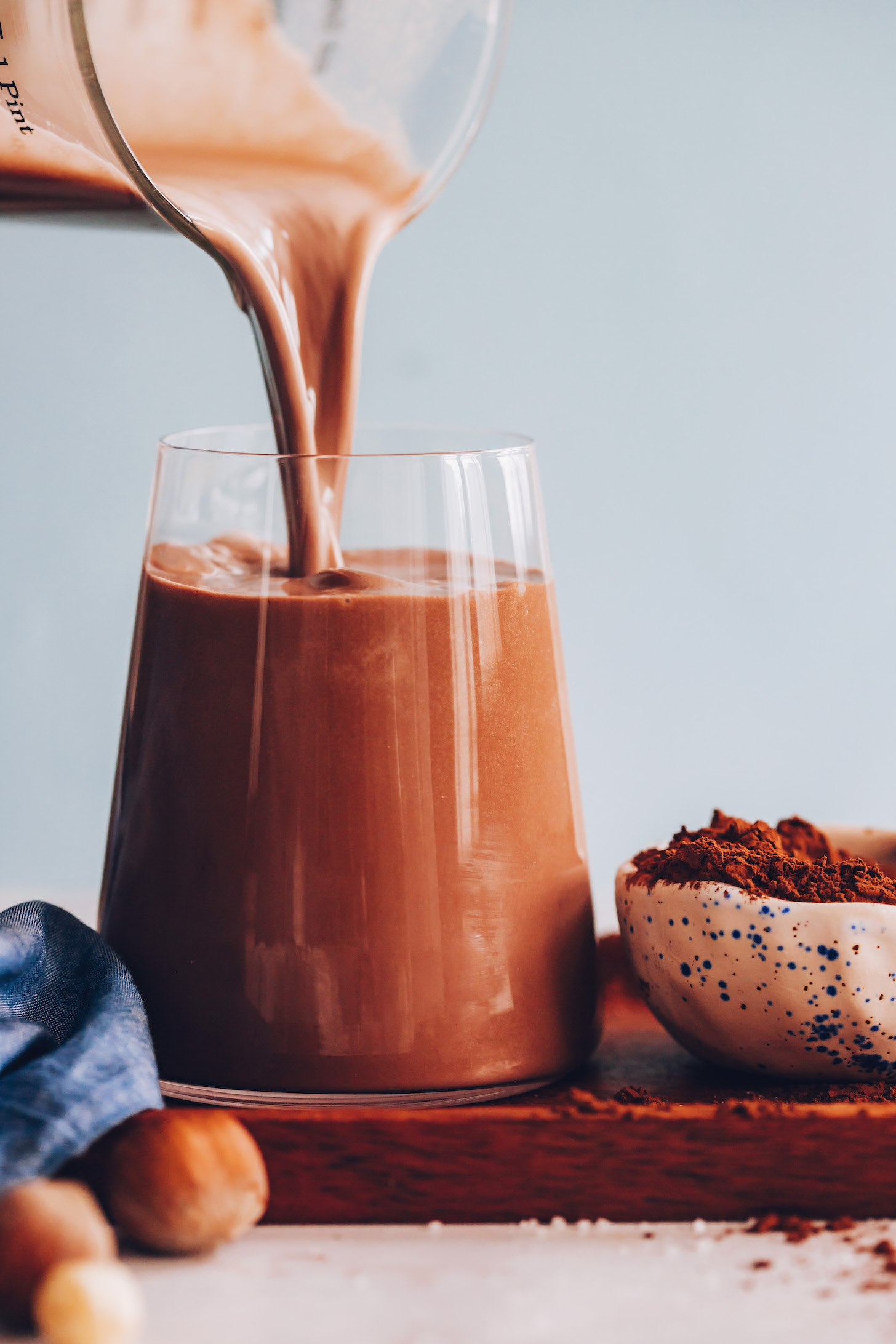 Pouring a glass of creamy chocolate hazelnut milk