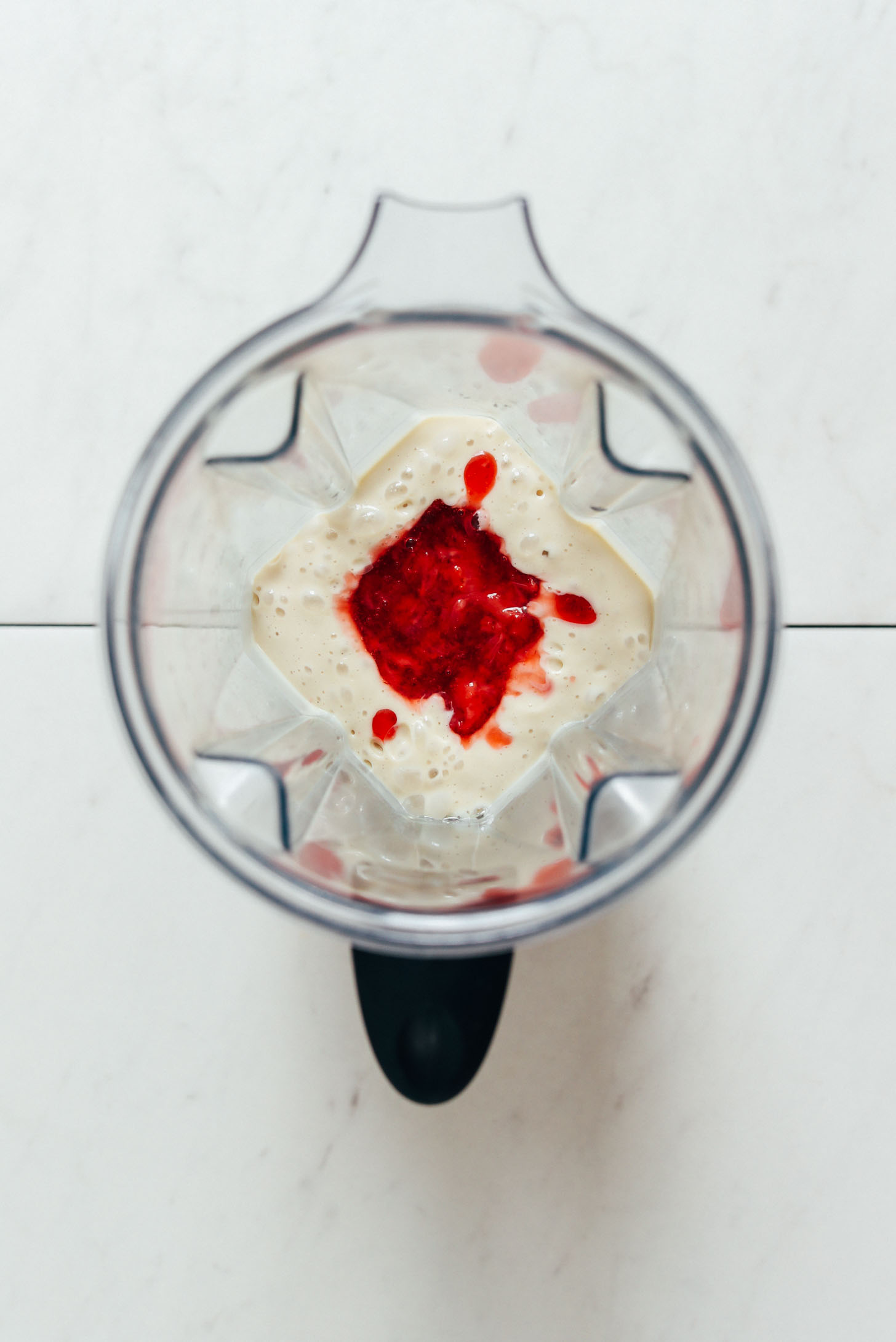 Blender with cashew coconut ice cream base with strawberry compote