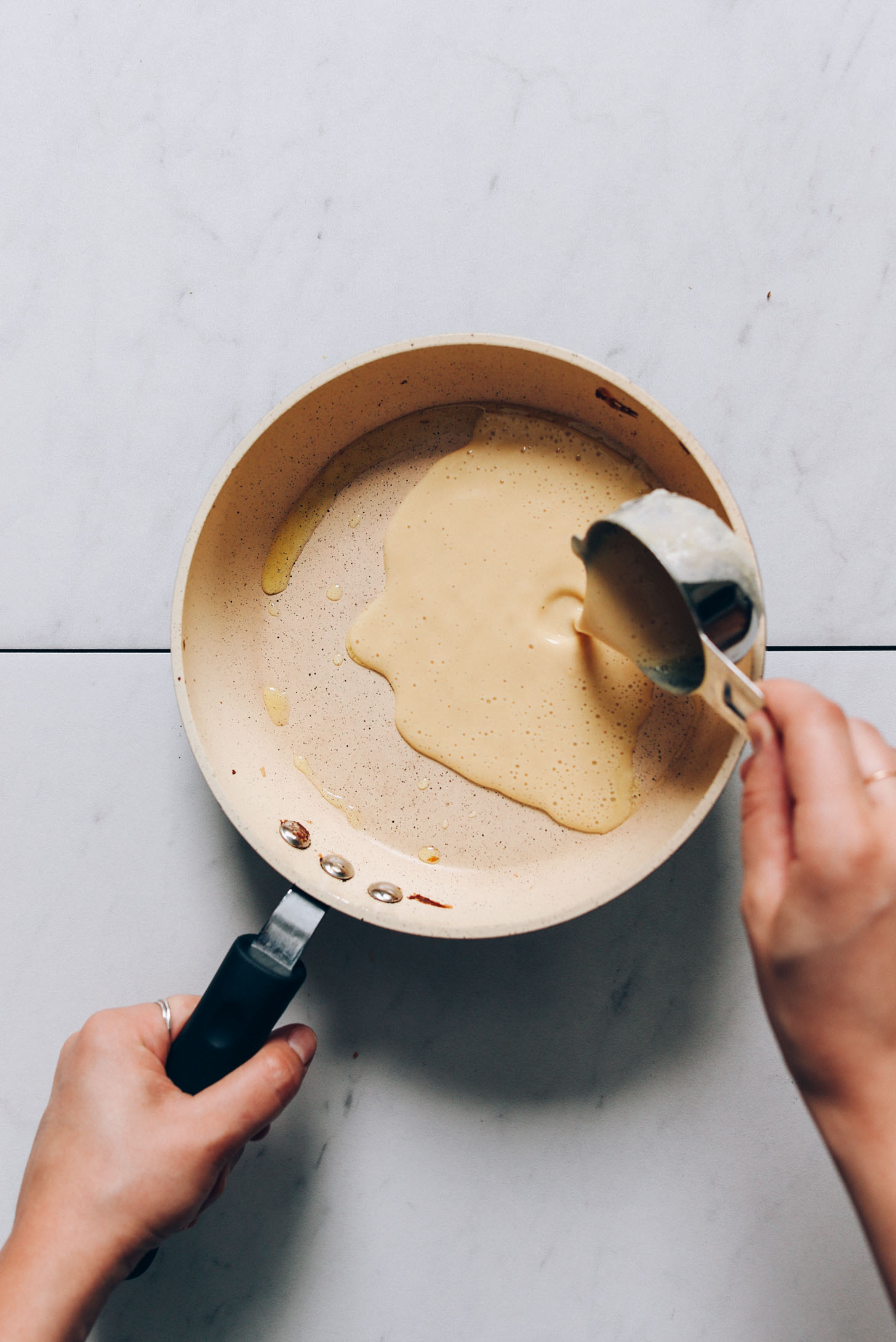 Pouring chickpea pancake batter into a small pan