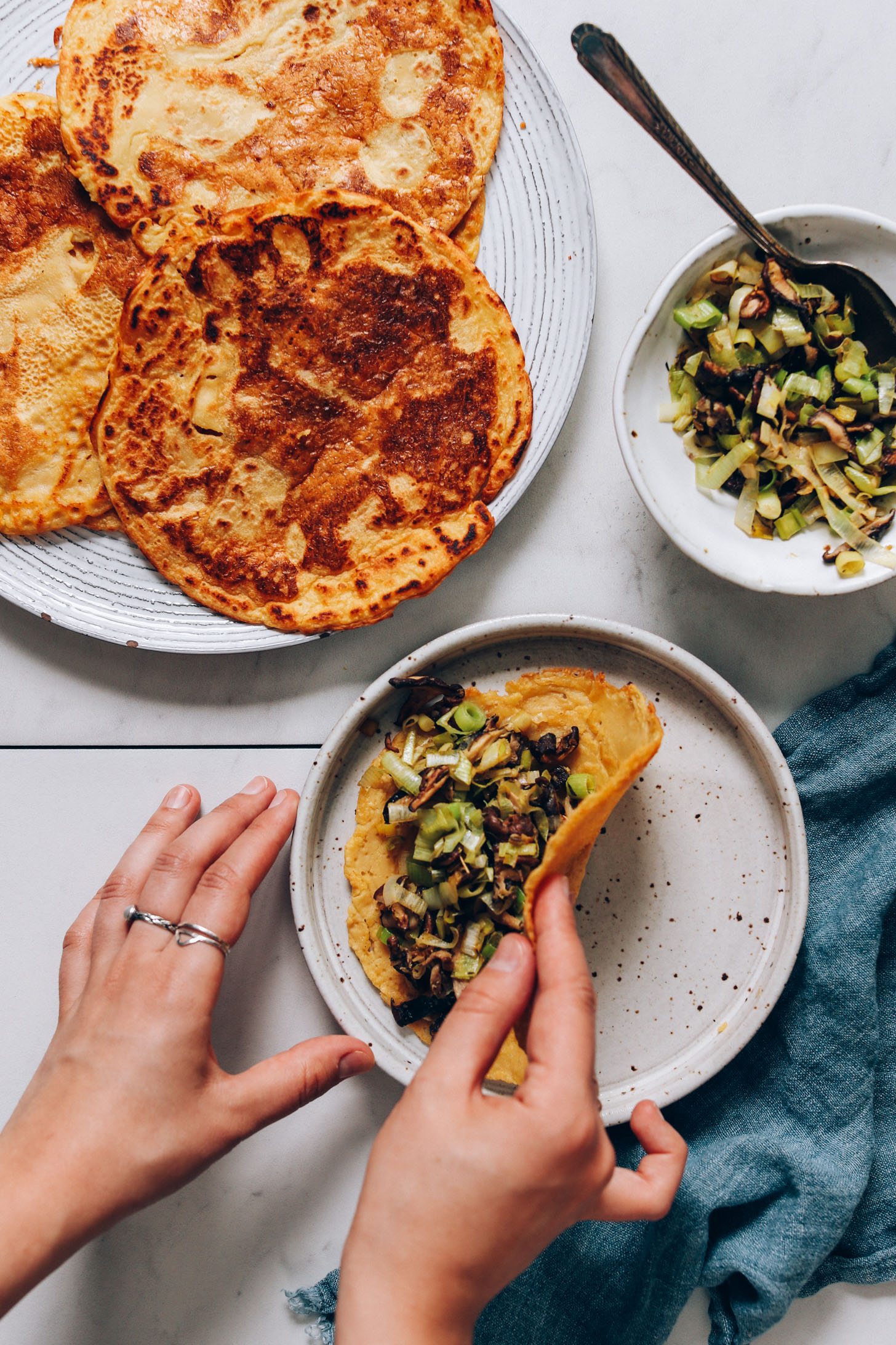 Folding a chickpea pancake with leek mushroom filling