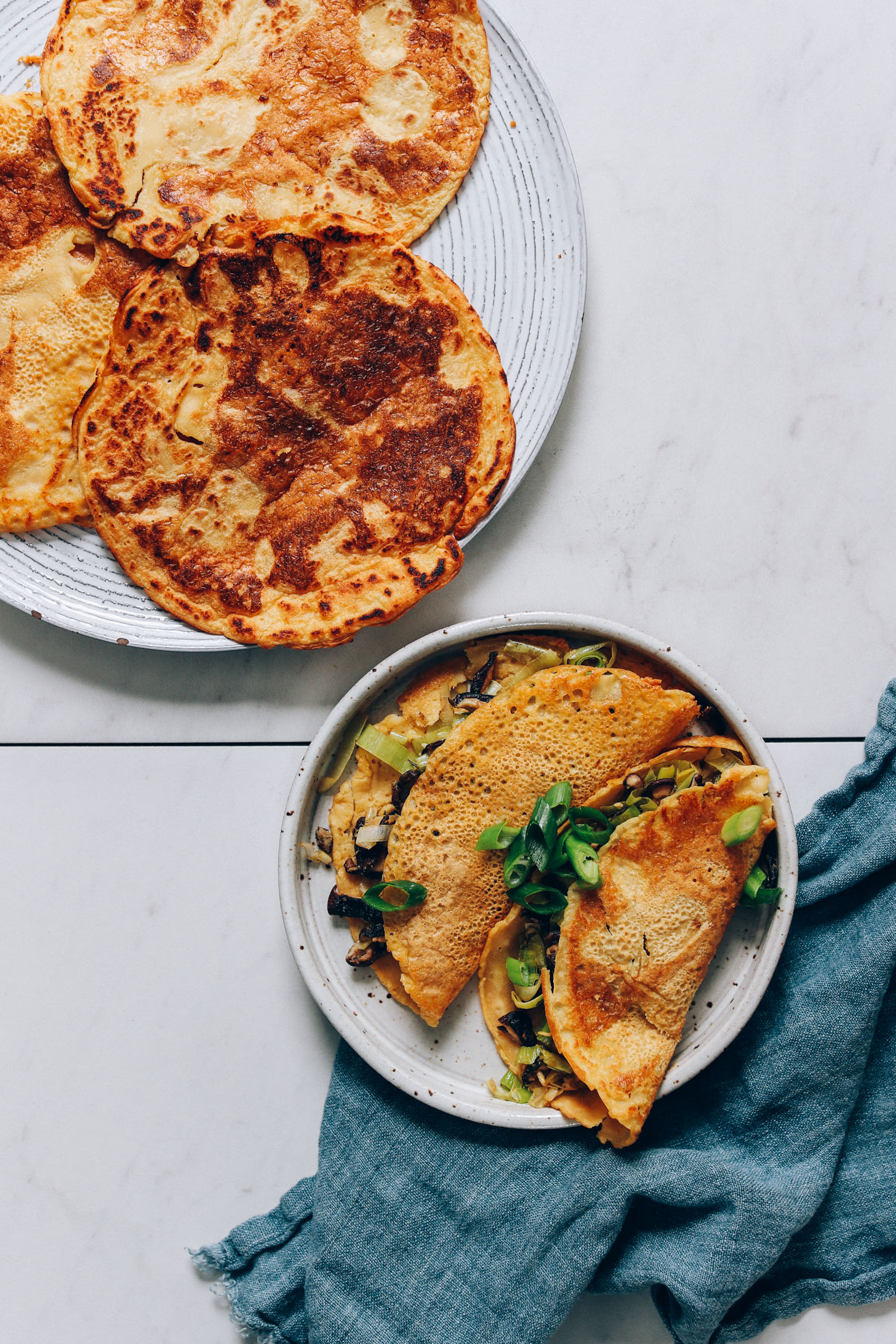 Plates of crispy chickpea pancakes with a leek mushroom filling