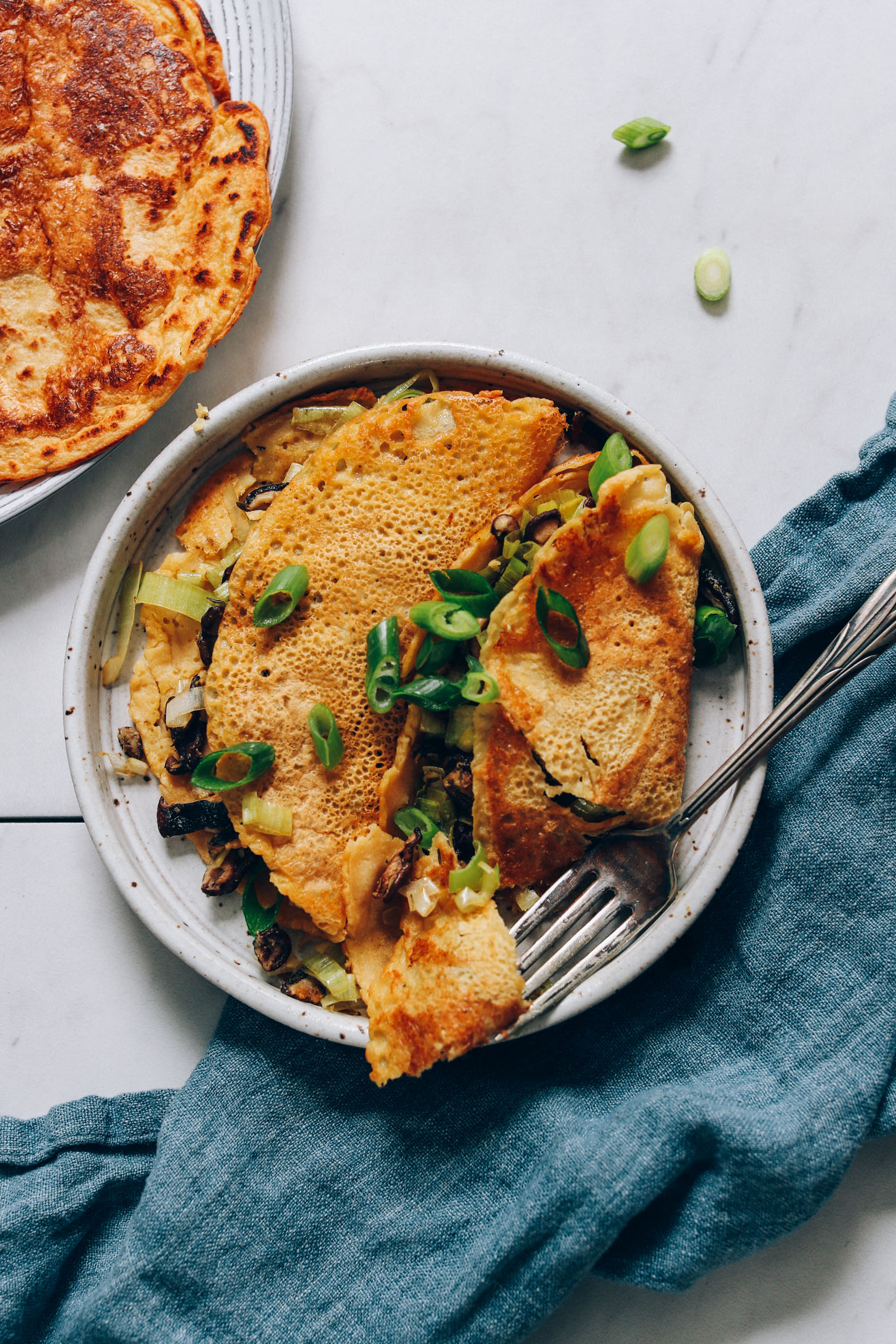 Fork resting on a plate of savory chickpea pancakes