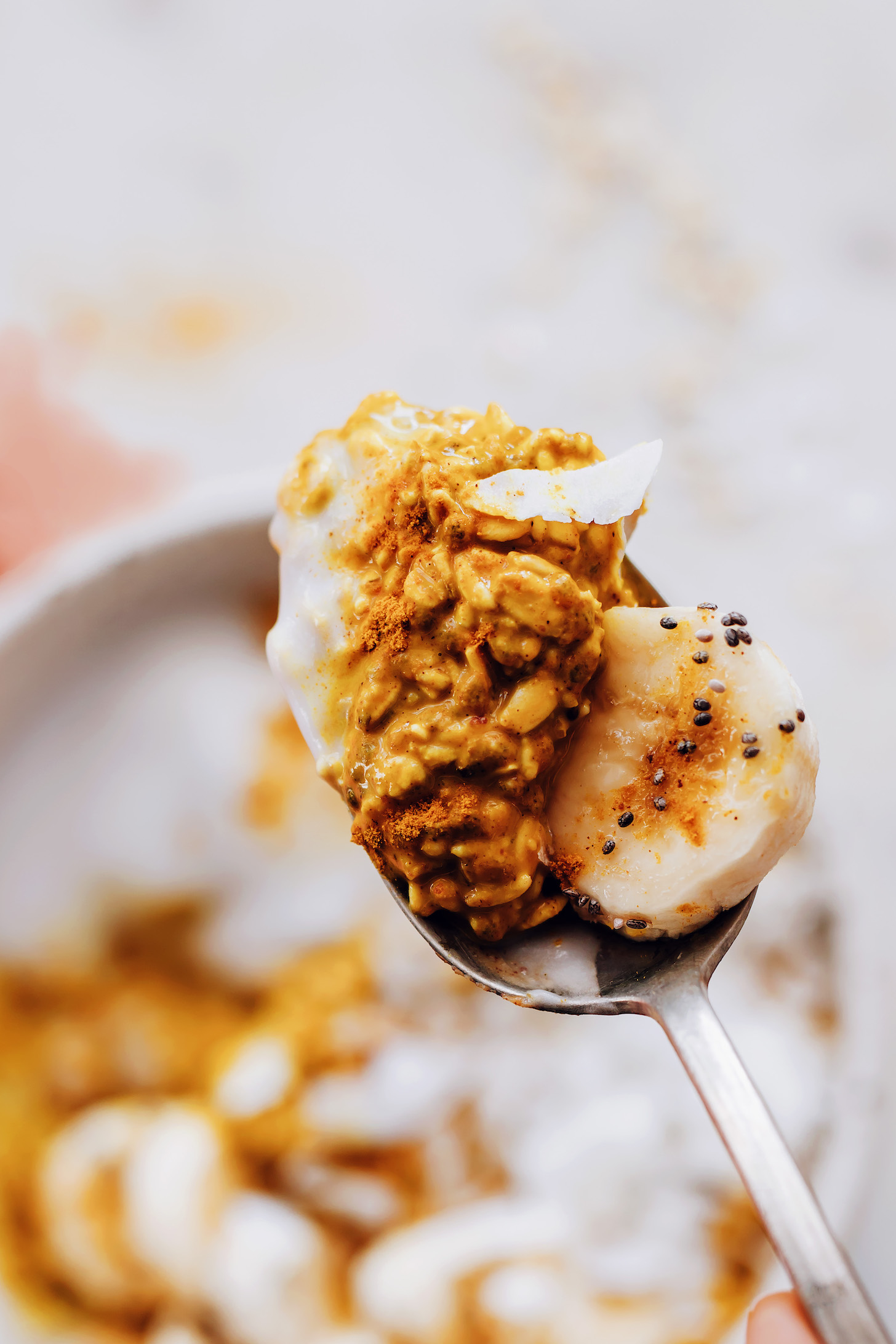 Holding up a spoonful of golden milk overnight oats