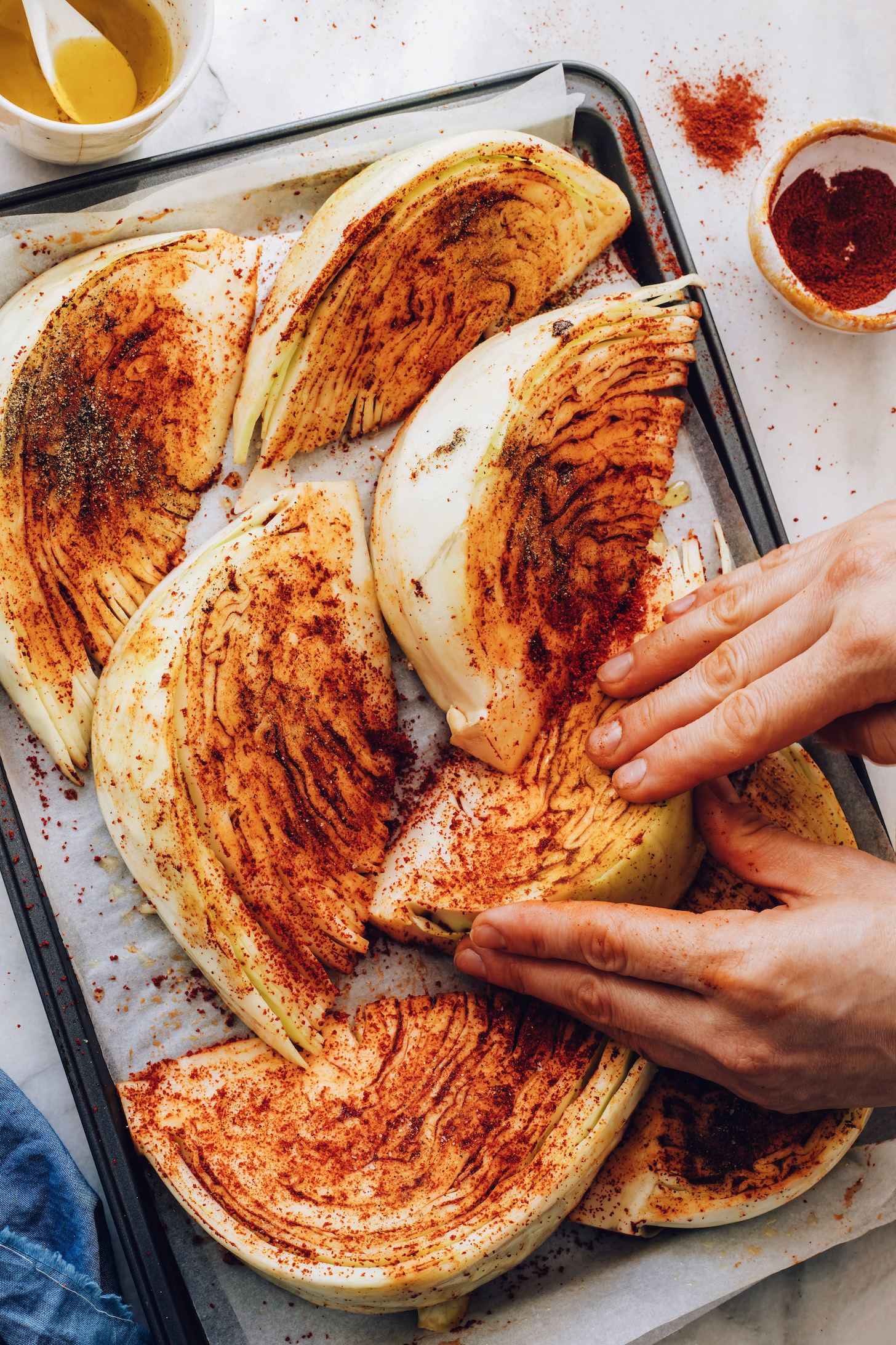 Rubbing shawarma spice mix onto cabbage wedges