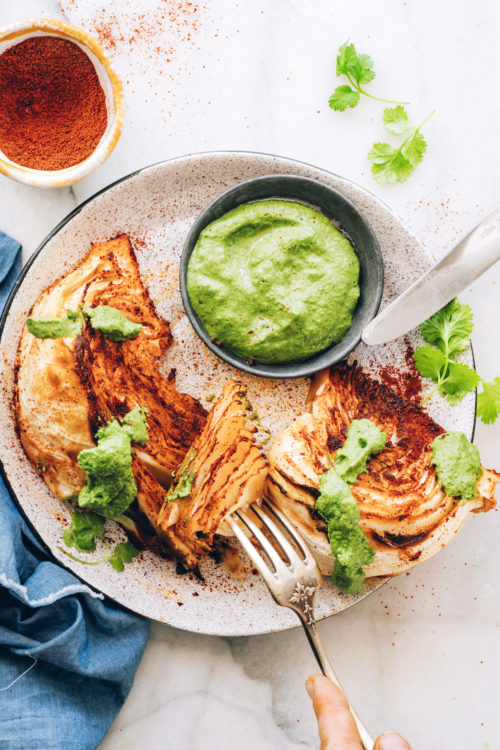 Fork pressing into a piece of a shawarma roasted cabbage wedge