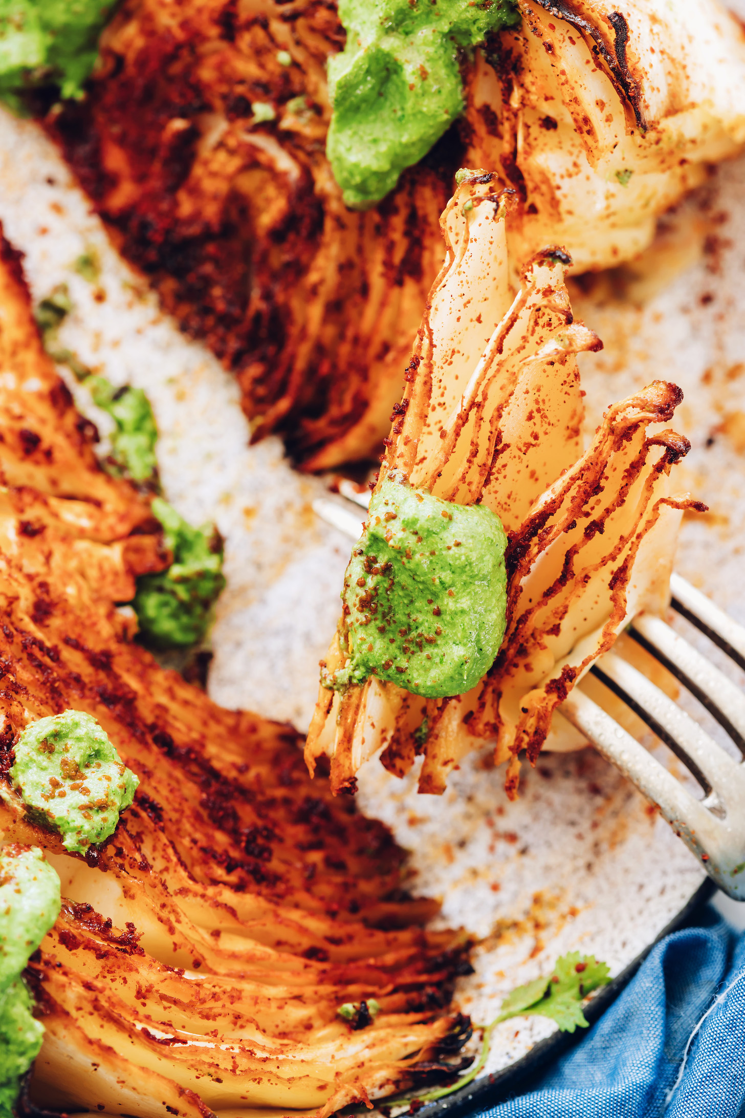 Close up shot of a fork holding a bite of a shawarma roasted cabbage wedge