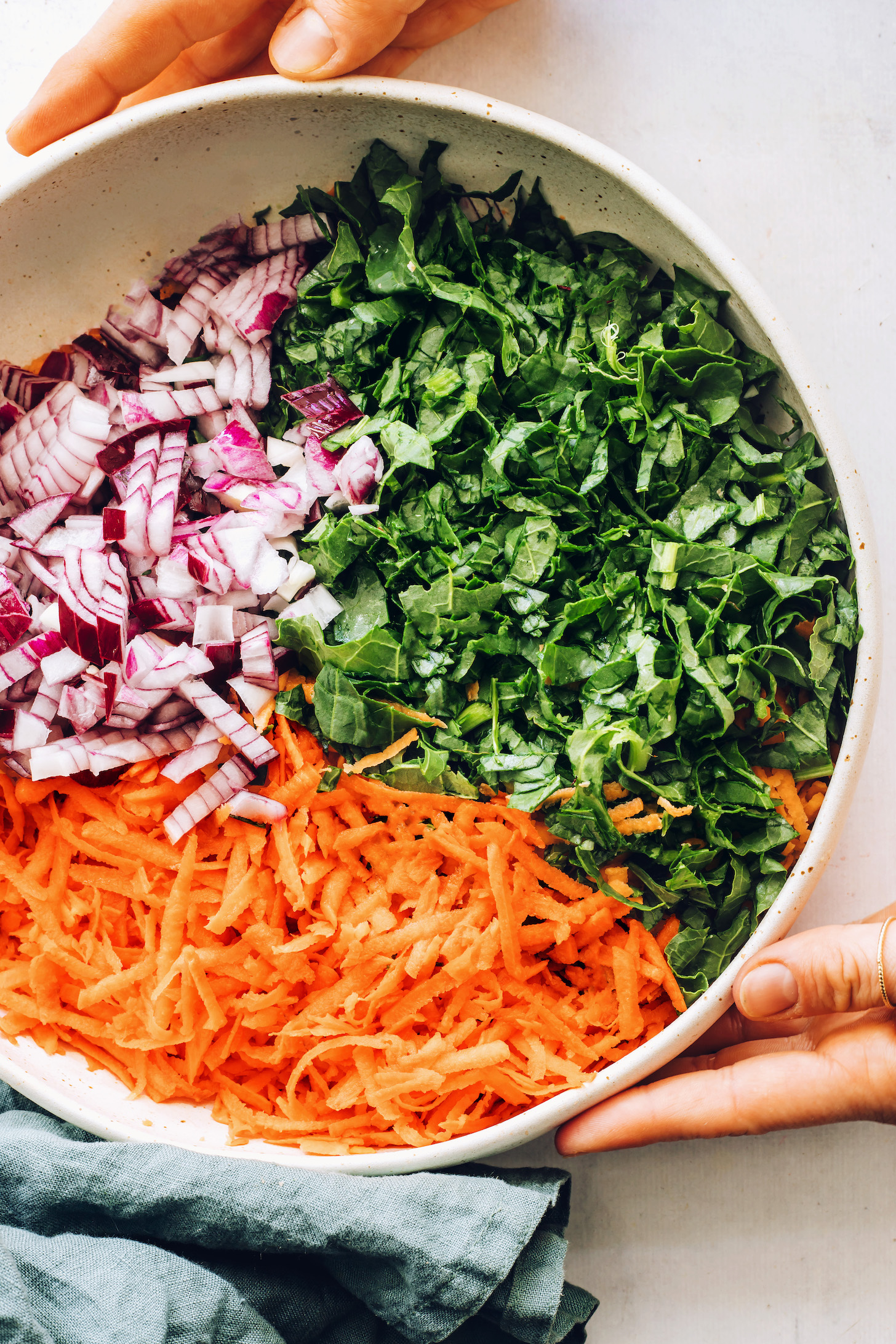 Bowl of red onion, shredded kale, and shredded sweet potato